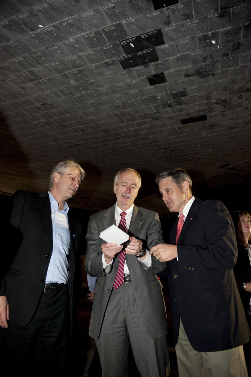 CAPE CANAVERAL, Fla. -- European Space Agency Director of Human Spaceflight Thomas Reiter, left, Associate Administrator for Space Operations Bill Gerstenmaier, and NASA Kennedy Space Center Director Bob Cabana check out a heat shield tile that protected space shuttle Endeavour on its successful trip home. Endeavour's final return from space completed the 16-day, 6.5-million-mile STS-134 mission. Main gear touchdown on the Shuttle Landing Facility's Runway 15 was at 2:34:51 a.m. EDT, followed by nose gear touchdown at 2:35:04 a.m., and wheelstop at 2:35:36 a.m. STS-134 delivered the Alpha Magnetic Spectrometer-2 (AMS) and the Express Logistics Carrier-3 (ELC-3) to the International Space Station. AMS will help researchers understand the origin of the universe and search for evidence of dark matter, strange matter and antimatter from the station. ELC-3 carried spare parts that will sustain station operations once the shuttles are retired from service. STS-134 was the 25th and final flight for Endeavour, which spent 299 days in space, orbited Earth 4,671 times and traveled 122,883,151 miles. Photo credit: NASA/Kim Shiflett