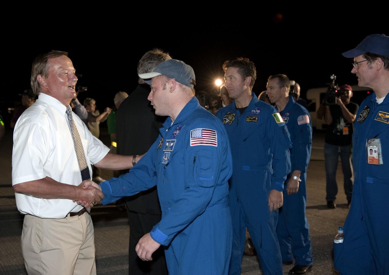 CAPE CANAVERAL, Fla. -- Shuttle Launch Director Mike Leinbach, left, greets space shuttle Endeavour's STS-134 crew members following their successful trip home. Endeavour's final return from space completed the 16-day, 6.5-million-mile STS-134 mission. Main gear touchdown on the Shuttle Landing Facility's Runway 15 was at 2:34:51 a.m. EDT, followed by nose gear touchdown at 2:35:04 a.m., and wheelstop at 2:35:36 a.m.  STS-134 delivered the Alpha Magnetic Spectrometer-2 (AMS) and the Express Logistics Carrier-3 (ELC-3) to the International Space Station. AMS will help researchers understand the origin of the universe and search for evidence of dark matter, strange matter and antimatter from the station. ELC-3 carried spare parts that will sustain station operations once the shuttles are retired from service. STS-134 was the 25th and final flight for Endeavour, which spent 299 days in space, orbited Earth 4,671 times and traveled 122,883,151 miles. Photo credit: NASA/Kim Shiflett
