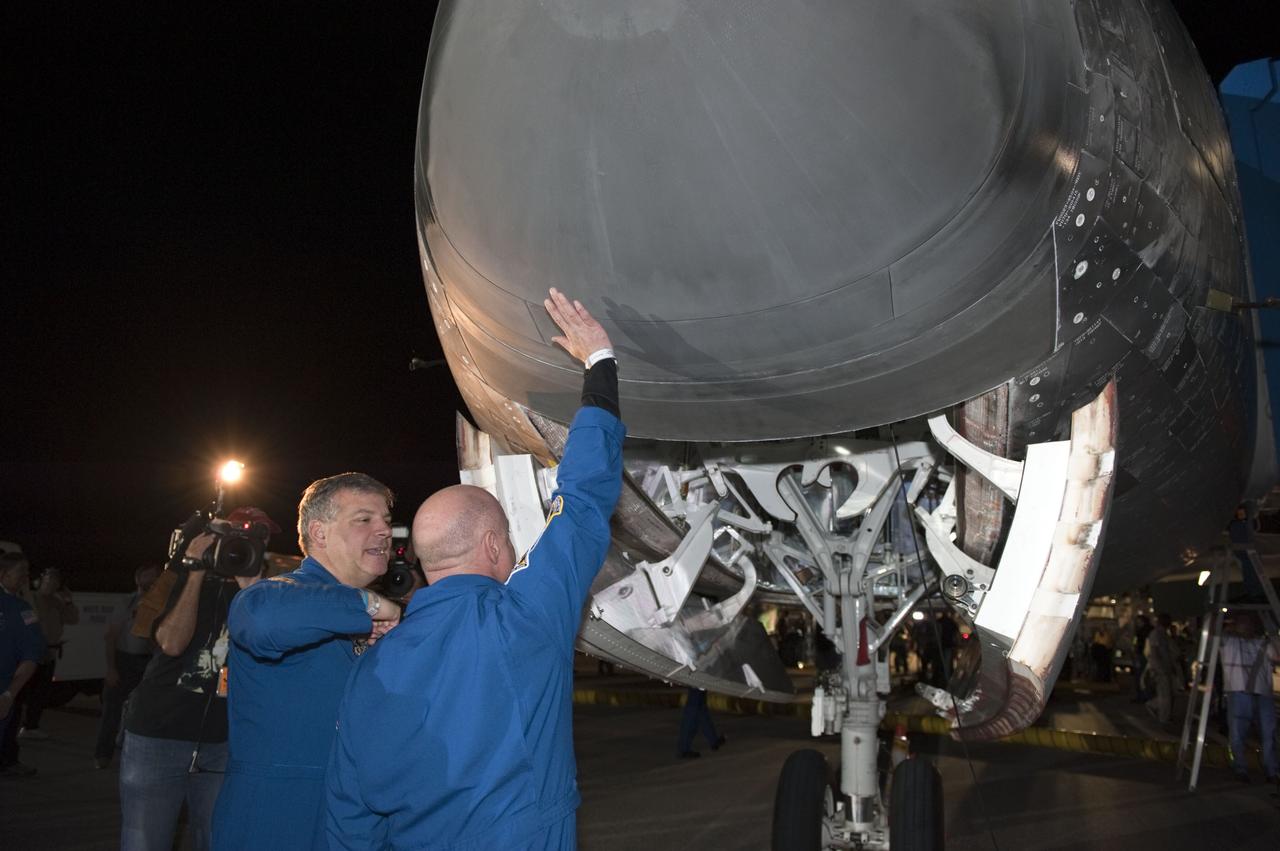 CAPE CANAVERAL, Fla. -- STS-134 Pilot Greg H. Johnson, left, and Commander Mark Kelly check out the nose of space shuttle Endeavour following the successful return to NASA's Kennedy Space Center in Florida. Endeavour's final return from space completed the 16-day, 6.5-million-mile STS-134 mission. Main gear touchdown on the Shuttle Landing Facility's Runway 15 was at 2:34:51 a.m. EDT, followed by nose gear touchdown at 2:35:04 a.m., and wheelstop at 2:35:36 a.m.  STS-134 delivered the Alpha Magnetic Spectrometer-2 (AMS) and the Express Logistics Carrier-3 (ELC-3) to the International Space Station. AMS will help researchers understand the origin of the universe and search for evidence of dark matter, strange matter and antimatter from the station. ELC-3 carried spare parts that will sustain station operations once the shuttles are retired from service. STS-134 was the 25th and final flight for Endeavour, which spent 299 days in space, orbited Earth 4,671 times and traveled 122,883,151 miles. Photo credit: NASA/Kim Shiflett