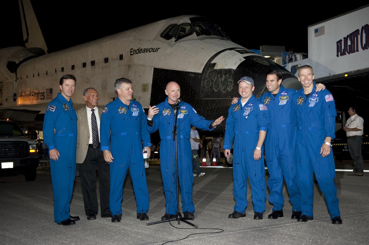 CAPE CANAVERAL, Fla. -- STS-134 Commander Mark Kelly addresses media gathered on the Shuttle Landing Facility at NASA's Kennedy Space Center in Florida following the successful landing of space shuttle Endeavour. From left, are the European Space Agency's Roberto Vittori, NASA Administrator Charlie Bolden, Pilot Greg H. Johnson, Kelly, and Mission Specialists Mike Fincke, Greg Chamitoff and Drew Feustel. The crew returned to Earth at 2:35 a.m. EDT on Runway 15, completing a 16-day, 6.5-million mile journey to the International Space Station. STS-134 delivered the Alpha Magnetic Spectrometer-2 (AMS) and the Express Logistics Carrier-3 (ELC-3) to the International Space Station. AMS will help researchers understand the origin of the universe and search for evidence of dark matter, strange matter and antimatter from the station. ELC-3 carried spare parts that will sustain station operations once the shuttles are retired from service. STS-134 was the 25th and final flight for Endeavour, which spent 299 days in space, orbited Earth 4,671 times and traveled 122,883,151 miles. Photo credit: NASA/Kim Shiflett