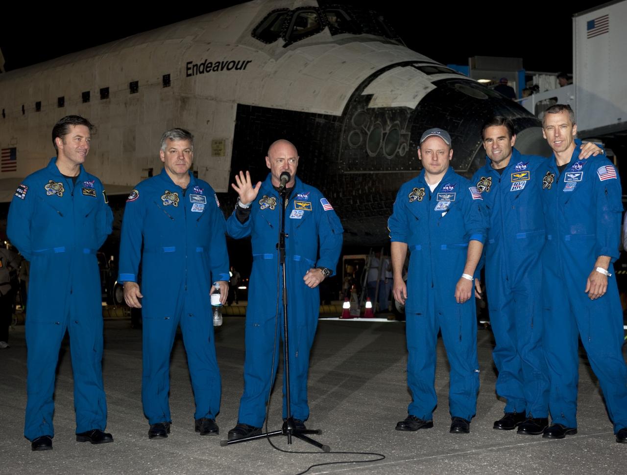 CAPE CANAVERAL, Fla. -- STS-134 Commander Mark Kelly addresses media gathered on the Shuttle Landing Facility at NASA's Kennedy Space Center in Florida following the successful landing of space shuttle Endeavour. From left, are the European Space Agency's Roberto Vittori, Pilot Greg H. Johnson, Kelly, and Mission Specialists Mike Fincke, Greg Chamitoff and Drew Feustel. The crew returned to Earth at 2:35 a.m. EDT on Runway 15, completing a 16-day, 6.5-million mile journey to the International Space Station.  STS-134 delivered the Alpha Magnetic Spectrometer-2 (AMS) and the Express Logistics Carrier-3 (ELC-3) to the International Space Station. AMS will help researchers understand the origin of the universe and search for evidence of dark matter, strange matter and antimatter from the station. ELC-3 carried spare parts that will sustain station operations once the shuttles are retired from service. STS-134 was the 25th and final flight for Endeavour, which spent 299 days in space, orbited Earth 4,671 times and traveled 122,883,151 miles. Photo credit: NASA/Kim Shiflett