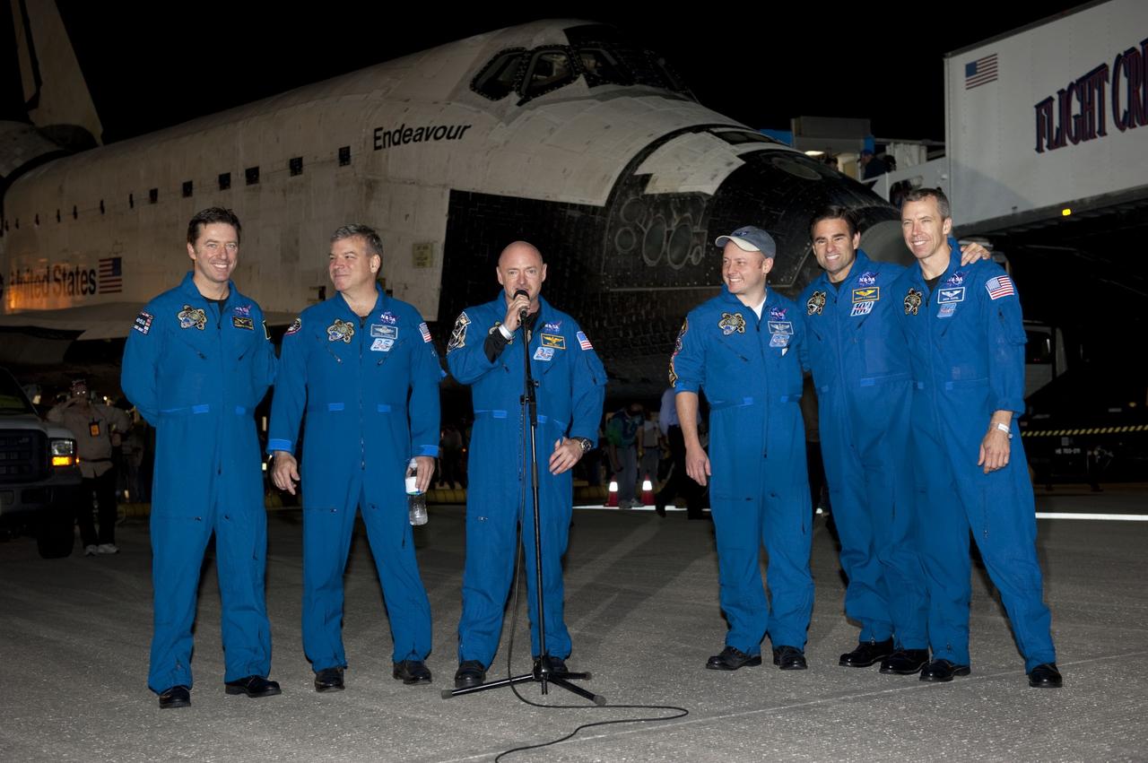CAPE CANAVERAL, Fla. -- STS-134 Commander Mark Kelly addresses media gathered on the Shuttle Landing Facility at NASA's Kennedy Space Center in Florida following the successful landing of space shuttle Endeavour. From left, are the European Space Agency's Roberto Vittori, Pilot Greg H. Johnson, Kelly, and Mission Specialists Mike Fincke, Greg Chamitoff and Drew Feustel. The crew returned to Earth at 2:35 a.m. EDT on Runway 15, completing a 16-day, 6.5-million mile journey to the International Space Station.  STS-134 delivered the Alpha Magnetic Spectrometer-2 (AMS) and the Express Logistics Carrier-3 (ELC-3) to the International Space Station. AMS will help researchers understand the origin of the universe and search for evidence of dark matter, strange matter and antimatter from the station. ELC-3 carried spare parts that will sustain station operations once the shuttles are retired from service. STS-134 was the 25th and final flight for Endeavour, which spent 299 days in space, orbited Earth 4,671 times and traveled 122,883,151 miles. Photo credit: NASA/Kim Shiflett