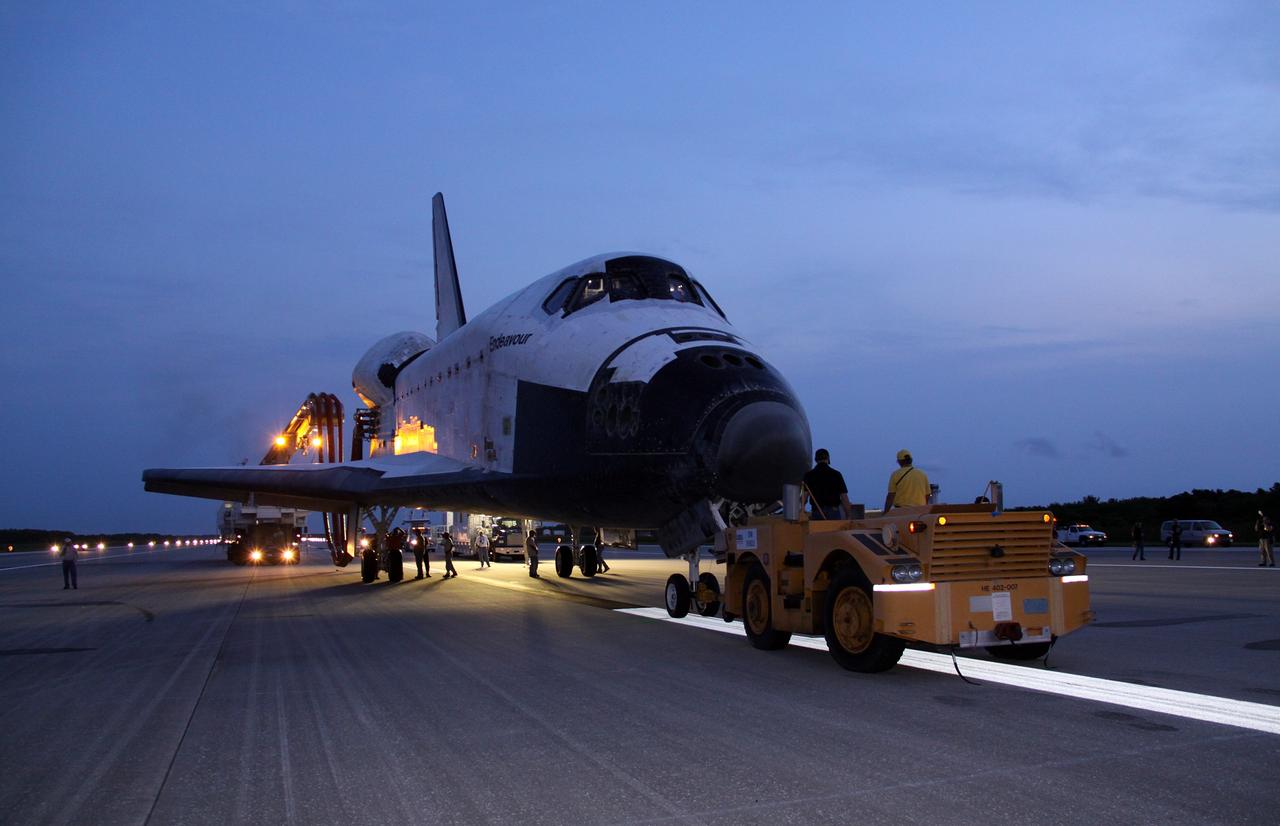 CAPE CANAVERAL, Fla. -- In the early morning hours after landing, space shuttle Endeavour's "towback" vehicle slowly pulls it from the Shuttle Landing Facility to Orbiter Processing Facility-1 at NASA's Kennedy Space Center in Florida. A purge unit that pumps conditioned air into a shuttle after landing is connected to Endeavour's aft end. Once inside the processing facility, Endeavour will be prepared for future public display.          Endeavour's final return from space completed the 16-day, 6.5-million-mile STS-134 mission. Main gear touchdown was at 2:34:51 a.m. EDT, followed by nose gear touchdown at 2:35:04 a.m., and wheelstop at 2:35:36 a.m.   Endeavour and its crew delivered the Alpha Magnetic Spectrometer-2 (AMS) and the Express Logistics Carrier-3 (ELC-3) to the International Space Station. AMS will help researchers understand the origin of the universe and search for evidence of dark matter, strange matter and antimatter from the station. ELC-3 carried spare parts that will sustain station operations once the shuttles are retired from service. STS-134 was the 25th and final flight for Endeavour, which spent 299 days in space, orbited Earth 4,671 times and traveled 122,883,151 miles. Photo credit: NASA/Jack Pfaller