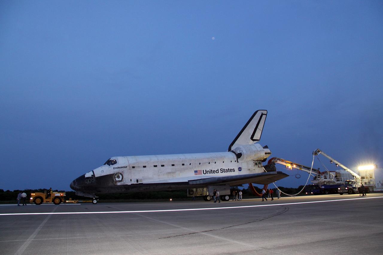 CAPE CANAVERAL, Fla. -- In the early morning hours after landing, space shuttle Endeavour's "towback" vehicle slowly pulls it from the Shuttle Landing Facility to Orbiter Processing Facility-1 at NASA's Kennedy Space Center in Florida. A purge unit that pumps conditioned air into a shuttle after landing is connected to Endeavour's aft end. Once inside the processing facility, Endeavour will be prepared for future public display.            Endeavour's final return from space completed the 16-day, 6.5-million-mile STS-134 mission. Main gear touchdown was at 2:34:51 a.m. EDT, followed by nose gear touchdown at 2:35:04 a.m., and wheelstop at 2:35:36 a.m.   Endeavour and its crew delivered the Alpha Magnetic Spectrometer-2 (AMS) and the Express Logistics Carrier-3 (ELC-3) to the International Space Station. AMS will help researchers understand the origin of the universe and search for evidence of dark matter, strange matter and antimatter from the station. ELC-3 carried spare parts that will sustain station operations once the shuttles are retired from service. STS-134 was the 25th and final flight for Endeavour, which spent 299 days in space, orbited Earth 4,671 times and traveled 122,883,151 miles. Photo credit: NASA/Jack Pfaller