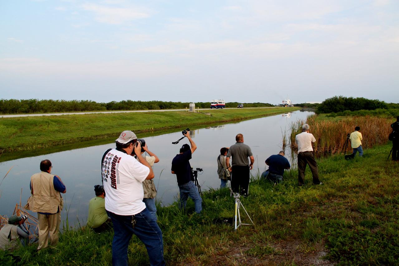 CAPE CANAVERAL, Fla. -- In the early morning hours after landing, media photograph space shuttle Endeavour as a "towback" vehicle slowly pulls it from the Shuttle Landing Facility to Orbiter Processing Facility-1 at NASA's Kennedy Space Center in Florida. Once inside the processing facility, Endeavour will be prepared for future public display.      Endeavour's final return from space completed the 16-day, 6.5-million-mile STS-134 mission. Main gear touchdown was at 2:34:51 a.m. EDT, followed by nose gear touchdown at 2:35:04 a.m., and wheelstop at 2:35:36 a.m.   Endeavour and its crew delivered the Alpha Magnetic Spectrometer-2 (AMS) and the Express Logistics Carrier-3 (ELC-3) to the International Space Station. AMS will help researchers understand the origin of the universe and search for evidence of dark matter, strange matter and antimatter from the station. ELC-3 carried spare parts that will sustain station operations once the shuttles are retired from service. STS-134 was the 25th and final flight for Endeavour, which spent 299 days in space, orbited Earth 4,671 times and traveled 122,883,151 miles. Photo credit: NASA/Jack Pfaller