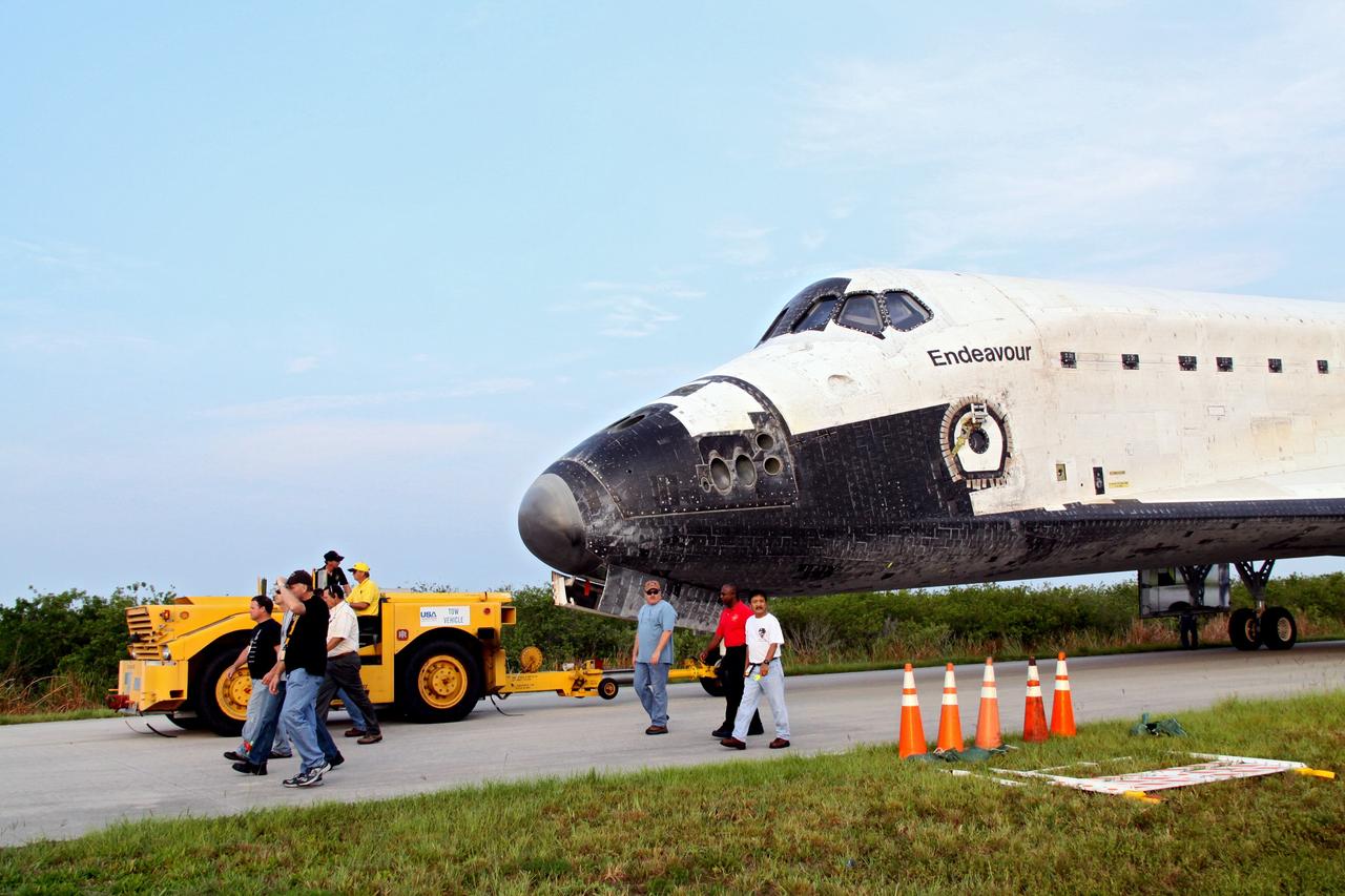 CAPE CANAVERAL, Fla. -- Workers accompany shuttle Endeavour as a "towback" vehicle slowly pulls it from the Shuttle Landing Facility to Orbiter Processing Facility-1 at NASA's Kennedy Space Center in Florida. A purge unit that pumps conditioned air into a shuttle after landing is connected to Endeavour's aft end. Once inside the processing facility, Endeavour will be prepared for future public display.                Endeavour's final return from space completed the 16-day, 6.5-million-mile STS-134 mission. Main gear touchdown was at 2:34:51 a.m. EDT, followed by nose gear touchdown at 2:35:04 a.m., and wheelstop at 2:35:36 a.m.   Endeavour and its crew delivered the Alpha Magnetic Spectrometer-2 (AMS) and the Express Logistics Carrier-3 (ELC-3) to the International Space Station. AMS will help researchers understand the origin of the universe and search for evidence of dark matter, strange matter and antimatter from the station. ELC-3 carried spare parts that will sustain station operations once the shuttles are retired from service. STS-134 was the 25th and final flight for Endeavour, which spent 299 days in space, orbited Earth 4,671 times and traveled 122,883,151 miles. Photo credit: NASA/Jack Pfaller
