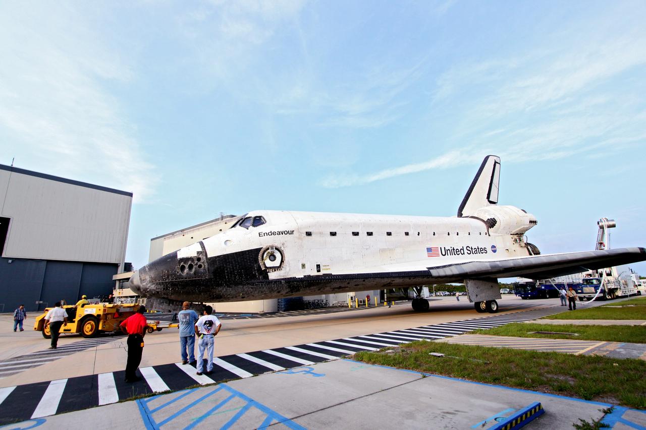 CAPE CANAVERAL, Fla. -- Workers accompany shuttle Endeavour as a "towback" vehicle slowly pulls it into Orbiter Processing Facility-1 at NASA's Kennedy Space Center in Florida. A purge unit that pumps conditioned air into a shuttle after landing is connected to Endeavour's aft end. Once inside the processing facility, Endeavour will be prepared for future public display.            Endeavour's final return from space completed the 16-day, 6.5-million-mile STS-134 mission. Main gear touchdown was at 2:34:51 a.m. EDT, followed by nose gear touchdown at 2:35:04 a.m., and wheelstop at 2:35:36 a.m.   Endeavour and its crew delivered the Alpha Magnetic Spectrometer-2 (AMS) and the Express Logistics Carrier-3 (ELC-3) to the International Space Station. AMS will help researchers understand the origin of the universe and search for evidence of dark matter, strange matter and antimatter from the station. ELC-3 carried spare parts that will sustain station operations once the shuttles are retired from service. STS-134 was the 25th and final flight for Endeavour, which spent 299 days in space, orbited Earth 4,671 times and traveled 122,883,151 miles. Photo credit: NASA/Jack Pfaller
