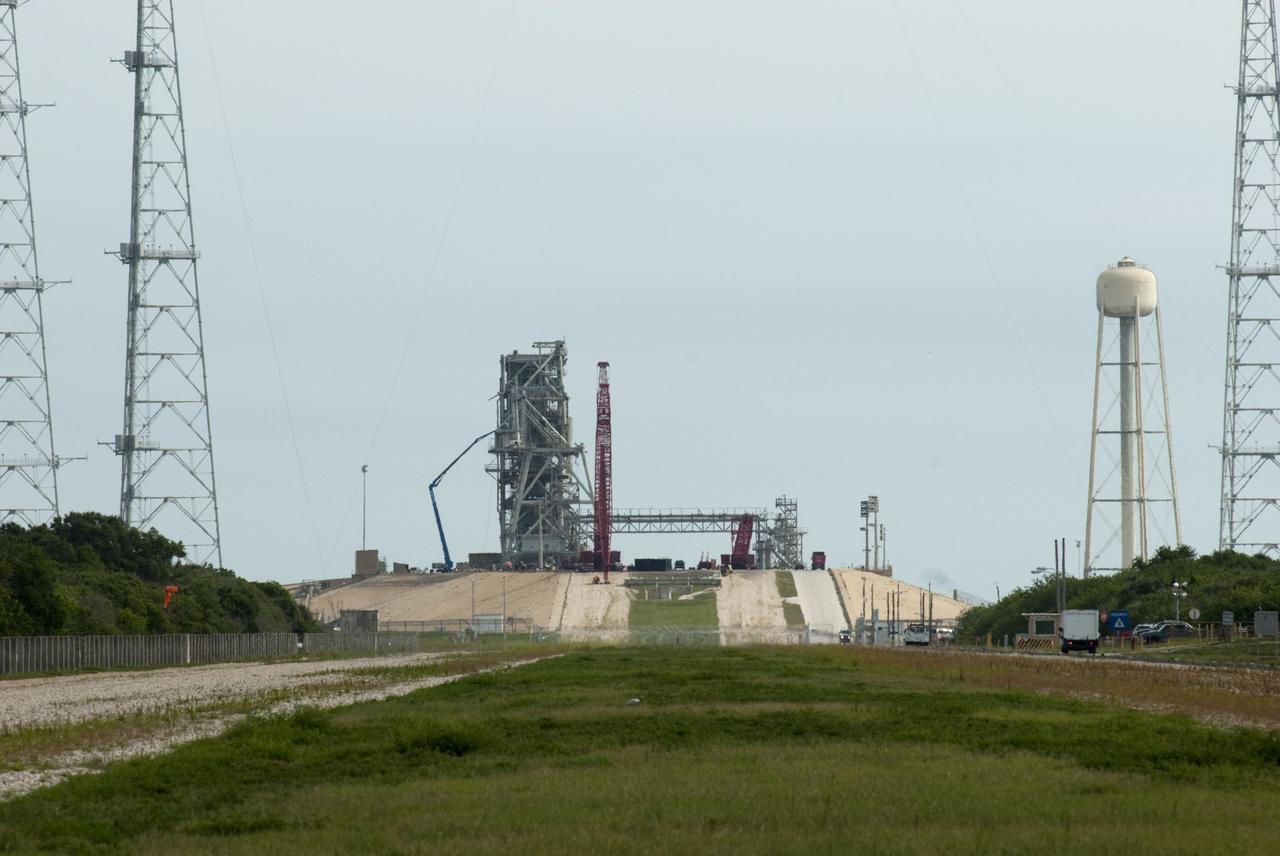 Cape Canaveral, Fla. -- Workers using a large crane dismantle the final sections of the rotating service structure on Launch Pad 39B at NASA's Kennedy Space Center in Florida. In 2009, the pad was no longer needed for the shuttle program, so it is being restructured for future use. Its new design will feature a "clean pad" for rockets to come with their own launcher, making it more versatile for a number of vehicles. The new lightning protection system, which was in place for the October 2009 launch of Ares I-X, will remain. For information on NASA's future plans, visit www.nasa.gov. Photo credit: NASA/Jim Grossmann