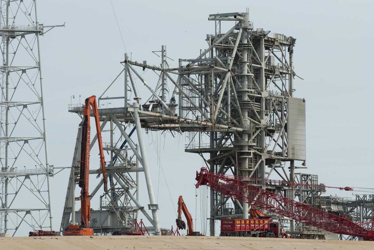 Cape Canaveral, Fla. -- Workers using a large crane dismantle the final sections of the rotating service structure on Launch Pad 39B at NASA's Kennedy Space Center in Florida. In 2009, the pad was no longer needed for the shuttle program, so it is being restructured for future use. Its new design will feature a "clean pad" for rockets to come with their own launcher, making it more versatile for a number of vehicles. The new lightning protection system, which was in place for the October 2009 launch of Ares I-X, will remain. For information on NASA's future plans, visit www.nasa.gov. Photo credit: NASA/Jim Grossmann
