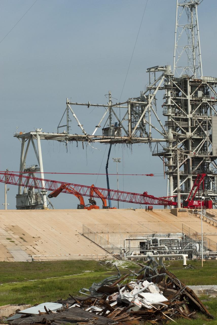 Cape Canaveral, Fla. -- Workers using a large crane dismantle the final sections of the rotating service structure on Launch Pad 39B at NASA's Kennedy Space Center in Florida. In 2009, the pad was no longer needed for the shuttle program, so it is being restructured for future use. Its new design will feature a "clean pad" for rockets to come with their own launcher, making it more versatile for a number of vehicles. The new lightning protection system, which was in place for the October 2009 launch of Ares I-X, will remain. For information on NASA's future plans, visit www.nasa.gov. Photo credit: NASA/Jim Grossmann