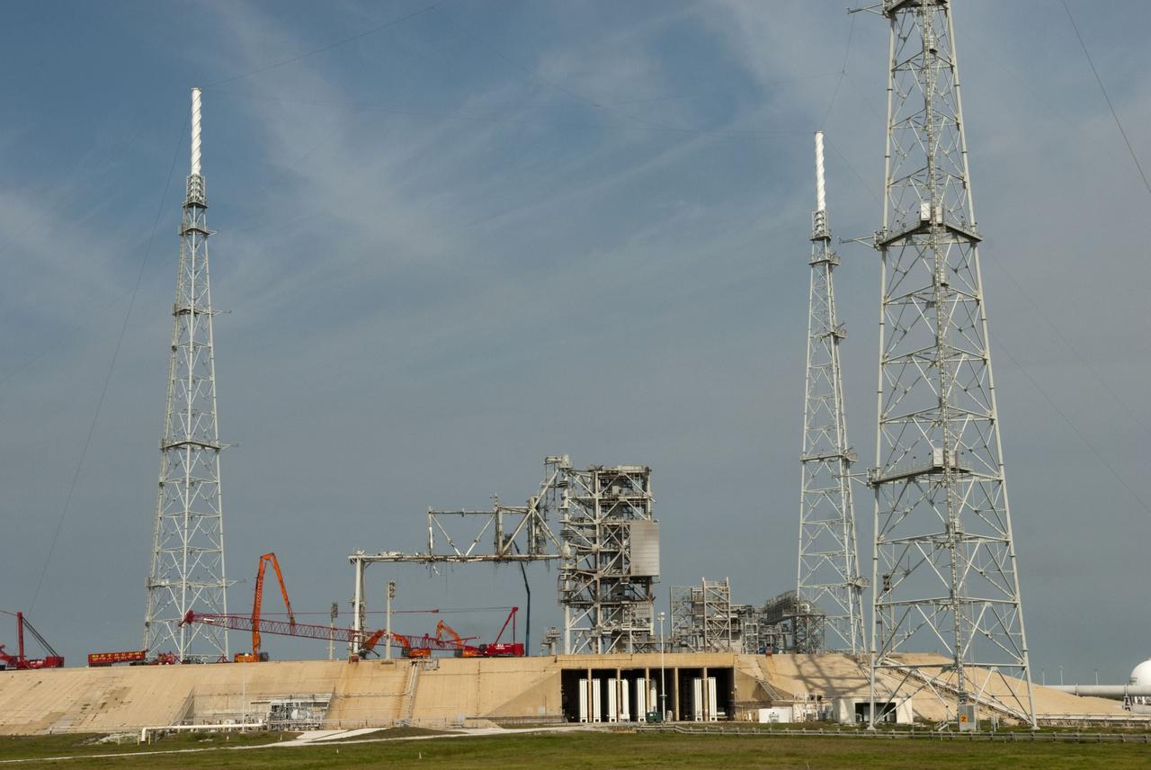 Cape Canaveral, Fla. -- Workers using a large crane dismantle the final sections of the rotating service structure on Launch Pad 39B at NASA's Kennedy Space Center in Florida. In 2009, the pad was no longer needed for the shuttle program, so it is being restructured for future use. Its new design will feature a "clean pad" for rockets to come with their own launcher, making it more versatile for a number of vehicles. The new lightning protection system, which was in place for the October 2009 launch of Ares I-X, will remain. For information on NASA's future plans, visit www.nasa.gov. Photo credit: NASA/Jim Grossmann