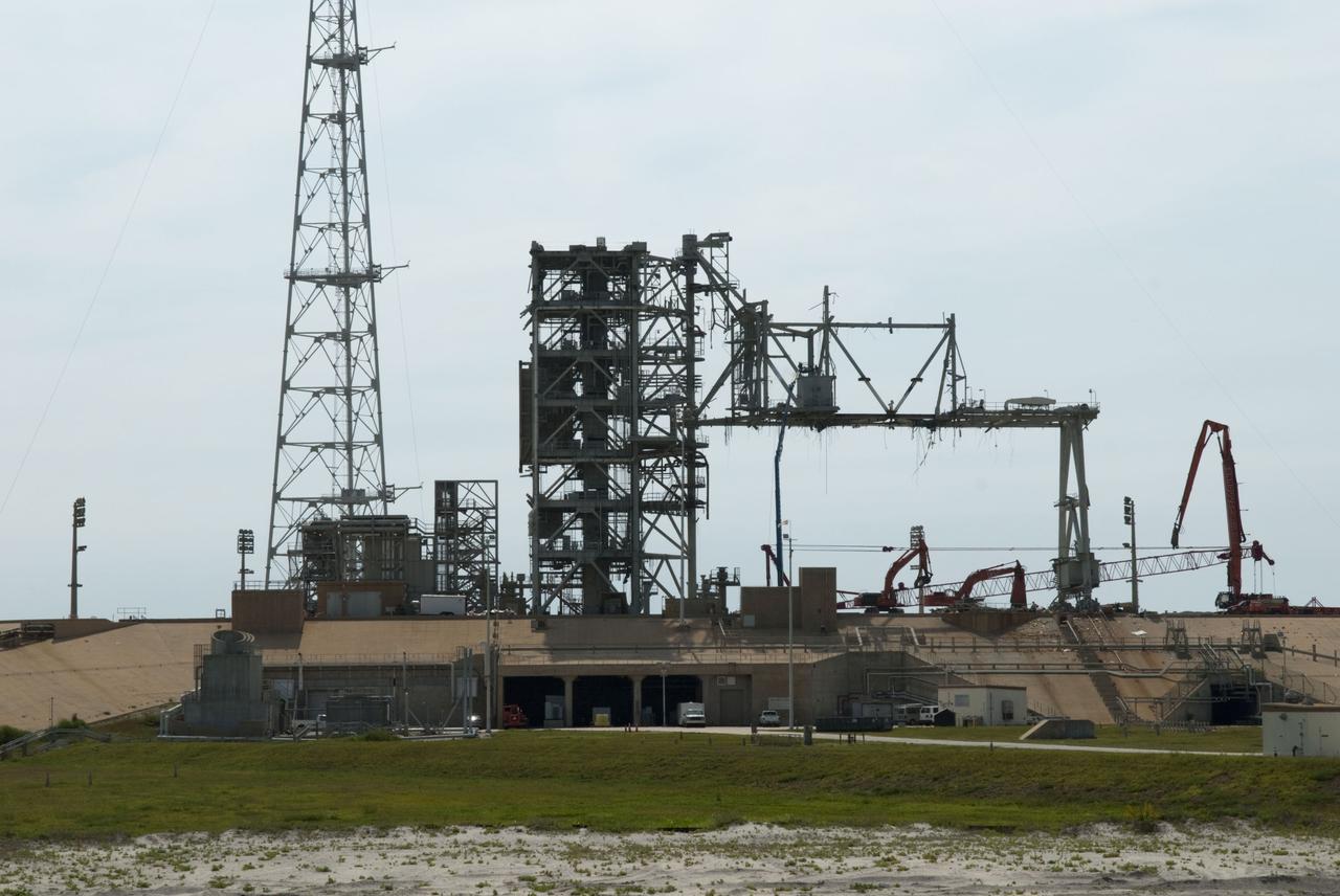 Cape Canaveral, Fla. -- Workers using a large crane dismantle the final sections of the rotating service structure on Launch Pad 39B at NASA's Kennedy Space Center in Florida. In 2009, the pad was no longer needed for the shuttle program, so it is being restructured for future use. Its new design will feature a "clean pad" for rockets to come with their own launcher, making it more versatile for a number of vehicles. The new lightning protection system, which was in place for the October 2009 launch of Ares I-X, will remain. For information on NASA's future plans, visit www.nasa.gov. Photo credit: NASA/Jim Grossmann