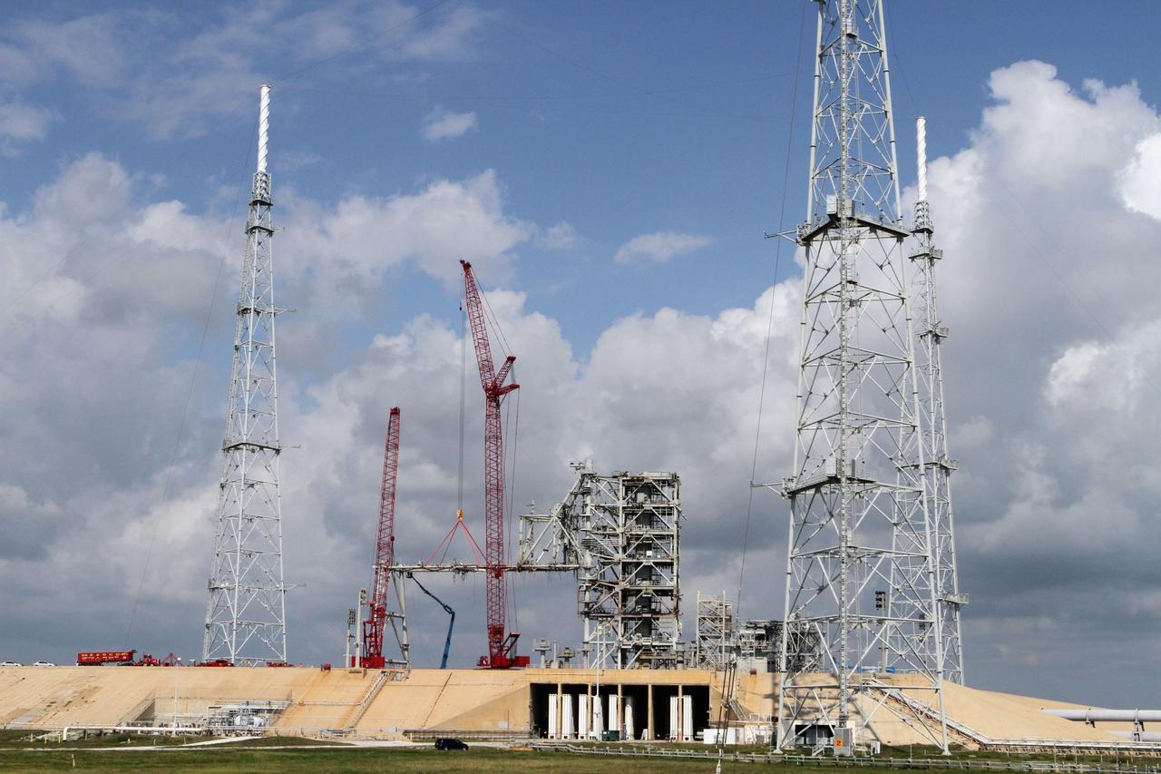 Cape Canaveral, Fla. -- Workers using a large crane remove the access arm section of the rotating service structure on Launch Pad 39B at NASA's Kennedy Space Center in Florida. In 2009, the pad was no longer needed for the shuttle program, so it is being restructured for future use. Its new design will feature a "clean pad" for rockets to come with their own launcher, making it more versatile for a number of vehicles. The new lightning protection system, which was in place for the October 2009 launch of Ares I-X, will remain. For information on NASA's future plans, visit www.nasa.gov. Photo credit: NASA/Cory Huston