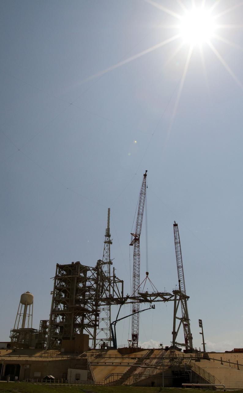 Cape Canaveral, Fla. -- Workers using a large crane remove the access arm section of the rotating service structure on Launch Pad 39B at NASA's Kennedy Space Center in Florida. In 2009, the pad was no longer needed for the shuttle program, so it is being restructured for future use. Its new design will feature a "clean pad" for rockets to come with their own launcher, making it more versatile for a number of vehicles. The new lightning protection system, which was in place for the October 2009 launch of Ares I-X, will remain. For information on NASA's future plans, visit www.nasa.gov. Photo credit: NASA/Cory Huston