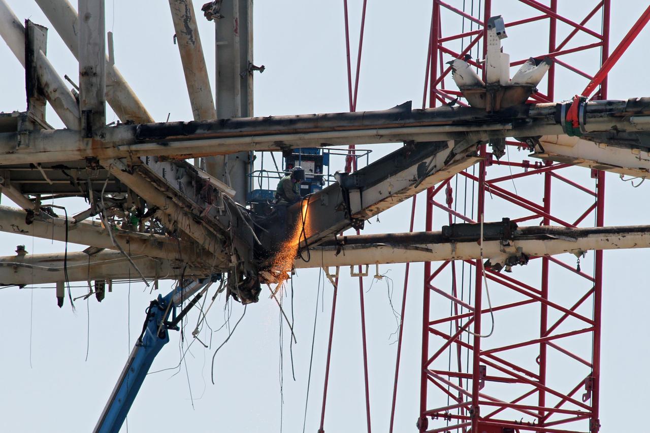Cape Canaveral, Fla. -- Workers using a large crane remove the access arm section of the rotating service structure on Launch Pad 39B at NASA's Kennedy Space Center in Florida. In 2009, the pad was no longer needed for the shuttle program, so it is being restructured for future use. Its new design will feature a "clean pad" for rockets to come with their own launcher, making it more versatile for a number of vehicles. The new lightning protection system, which was in place for the October 2009 launch of Ares I-X, will remain. For information on NASA's future plans, visit www.nasa.gov. Photo credit: NASA/Cory Huston