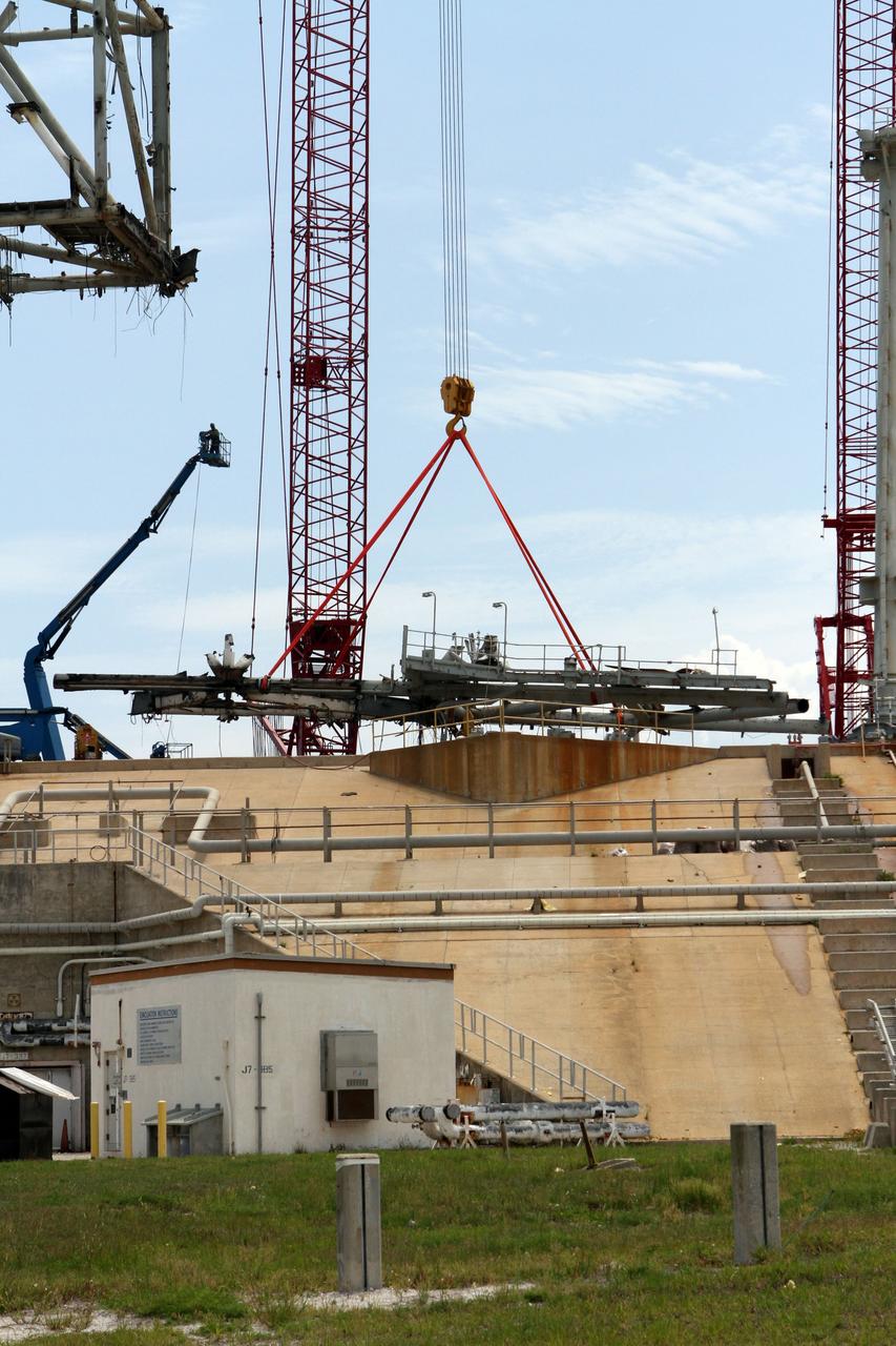 Cape Canaveral, Fla. -- Workers using a large crane remove the access arm section of the rotating service structure on Launch Pad 39B at NASA's Kennedy Space Center in Florida. In 2009, the pad was no longer needed for the shuttle program, so it is being restructured for future use. Its new design will feature a "clean pad" for rockets to come with their own launcher, making it more versatile for a number of vehicles. The new lightning protection system, which was in place for the October 2009 launch of Ares I-X, will remain. For information on NASA's future plans, visit www.nasa.gov. Photo credit: NASA/Cory Huston