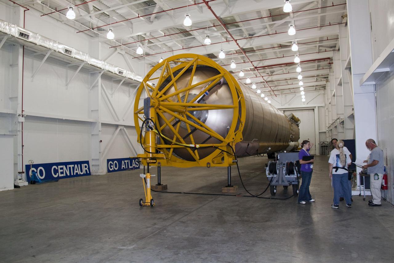 CAPE CANAVERAL, Fla. -- At Cape Canaveral Air Force Station in Florida, workers prepare the first stage of a United Launch Alliance Atlas V rocket for transport from its hangar at the Atlas Spaceflight Operations Center to Launch Complex 41.                NASA's Juno spacecraft is scheduled to launch aboard an Atlas V from Cape Canaveral, Fla. Aug. 5.The solar-powered spacecraft will orbit Jupiter's poles 33 times to find out more about the gas giant's origins, structure, atmosphere and magnetosphere and investigate the existence of a solid planetary core. For more information visit: www.nasa.gov/juno. Photo credit: NASA/Jack Pfaller