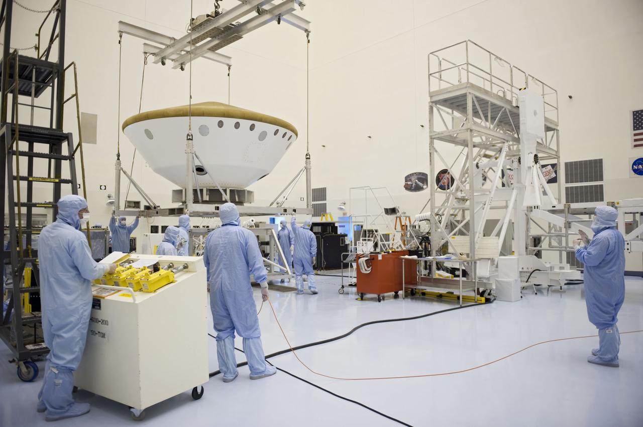 Cape Canaveral, Fla. -- At the Payload Hazardous Servicing Facility at NASA's Kennedy Space Center in Florida, technicians using an overhead crane, move the aeroshell, a component of NASA's Mars Science Laboratory (MSL), back to a work stand after a spin and balance test. The aeroshell consists of the backshell which carries the parachute and several components used during later stages of entry, descent and landing, and the spacecraft's heat shield. MSL's components include a compact car-sized rover, Curiosity, which has 10 science instruments designed to search for evidence on whether Mars has had environments favorable to microbial life, including chemical ingredients for life. The unique rover will use a laser to look inside rocks and release its gasses so that the rover’s spectrometer can analyze and send the data back to Earth. Launch of MSL aboard a United Launch Alliance Atlas V rocket is scheduled for Nov. 25 from Space Launch Complex 41 on Cape Canaveral Air Force Station in Florida. For more information, visit http://www.nasa.gov/msl. Photo credit: NASA/Kim Shiflett