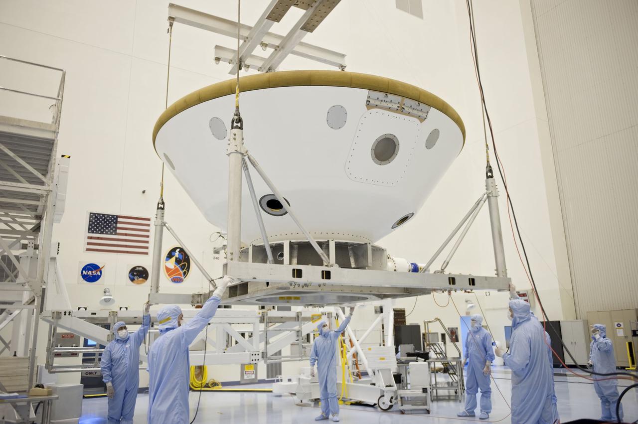 Cape Canaveral, Fla. -- At the Payload Hazardous Servicing Facility at NASA's Kennedy Space Center in Florida, technicians using an overhead crane, move the aeroshell, a component of NASA's Mars Science Laboratory (MSL), back to a work stand after a spin and balance test. The aeroshell consists of the backshell which carries the parachute and several components used during later stages of entry, descent and landing, and the spacecraft's heat shield. MSL's components include a compact car-sized rover, Curiosity, which has 10 science instruments designed to search for evidence on whether Mars has had environments favorable to microbial life, including chemical ingredients for life. The unique rover will use a laser to look inside rocks and release its gasses so that the rover’s spectrometer can analyze and send the data back to Earth. Launch of MSL aboard a United Launch Alliance Atlas V rocket is scheduled for Nov. 25 from Space Launch Complex 41 on Cape Canaveral Air Force Station in Florida. For more information, visit http://www.nasa.gov/msl. Photo credit: NASA/Kim Shiflett