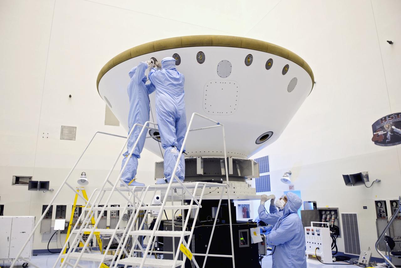 Cape Canaveral, Fla. -- At the Payload Hazardous Servicing Facility at NASA's Kennedy Space Center in Florida, technicians add weights (ejectable ballast mass) to the aeroshell, a component of NASA's Mars Science Laboratory (MSL), in order to conduct a spin and balance test. The aeroshell consists of the backshell which carries the parachute and several components used during later stages of entry, descent and landing, and the spacecraft's heat shield.          MSL's components include a compact car-sized rover, Curiosity, which has 10 science instruments designed to search for evidence on whether Mars has had environments favorable to microbial life, including chemical ingredients for life.  The unique rover will use a laser to look inside rocks and release its gasses so that the rover’s spectrometer can analyze and send the data back to Earth. Launch of MSL aboard a United Launch Alliance Atlas V rocket is scheduled for Nov. 25 from Space Launch Complex 41 on Cape Canaveral Air Force Station in Florida. For more information, visit http://www.nasa.gov/msl. Photo credit: NASA/Jim Grossmann