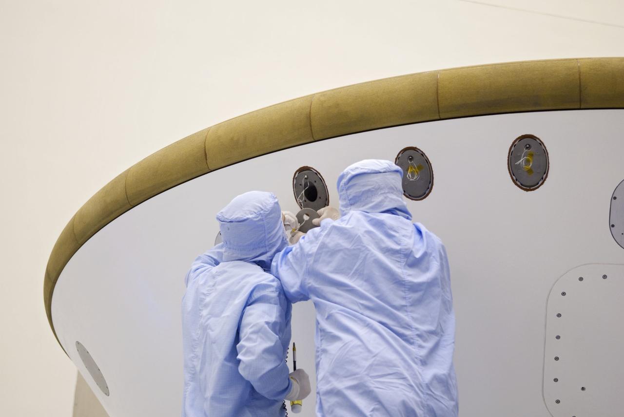 Cape Canaveral, Fla. -- At the Payload Hazardous Servicing Facility at NASA's Kennedy Space Center in Florida, technicians add weights (ejectable ballast mass) to the aeroshell, a component of NASA's Mars Science Laboratory (MSL), in order to conduct a spin and balance test. The aeroshell consists of the backshell which carries the parachute and several components used during later stages of entry, descent and landing, and the spacecraft's heat shield.          MSL's components include a compact car-sized rover, Curiosity, which has 10 science instruments designed to search for evidence on whether Mars has had environments favorable to microbial life, including chemical ingredients for life.  The unique rover will use a laser to look inside rocks and release its gasses so that the rover’s spectrometer can analyze and send the data back to Earth. Launch of MSL aboard a United Launch Alliance Atlas V rocket is scheduled for Nov. 25 from Space Launch Complex 41 on Cape Canaveral Air Force Station in Florida. For more information, visit http://www.nasa.gov/msl. Photo credit: NASA/Jim Grossmann