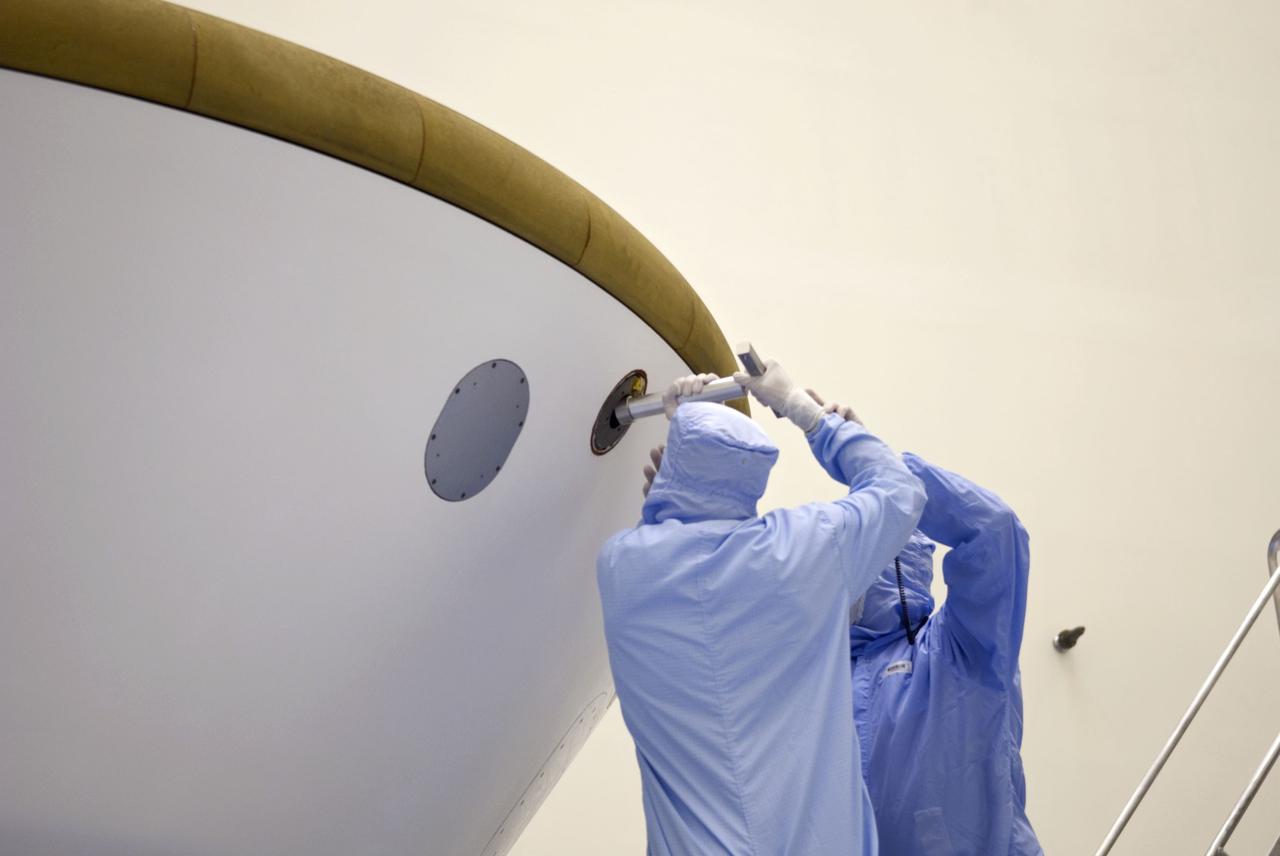 Cape Canaveral, Fla. -- At the Payload Hazardous Servicing Facility at NASA's Kennedy Space Center in Florida, technicians add weights (ejectable ballast mass) to the aeroshell, a component of NASA's Mars Science Laboratory (MSL), in order to conduct a spin and balance test. The aeroshell consists of the backshell which carries the parachute and several components used during later stages of entry, descent and landing, and the spacecraft's heat shield.          MSL's components include a compact car-sized rover, Curiosity, which has 10 science instruments designed to search for evidence on whether Mars has had environments favorable to microbial life, including chemical ingredients for life.  The unique rover will use a laser to look inside rocks and release its gasses so that the rover’s spectrometer can analyze and send the data back to Earth. Launch of MSL aboard a United Launch Alliance Atlas V rocket is scheduled for Nov. 25 from Space Launch Complex 41 on Cape Canaveral Air Force Station in Florida. For more information, visit http://www.nasa.gov/msl. Photo credit: NASA/Jim Grossmann