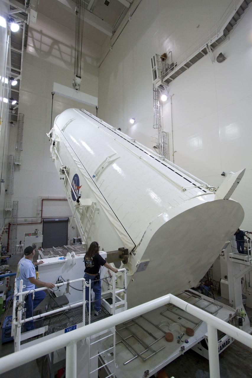 CAPE CANAVERAL, Fla. -- Workers monitor the progress of a canister, carrying the Raffaello multi-purpose logistics module, or MPLM, for the STS-135 mission, as it is rotated from a horizontal to vertical position in the Canister Rotation Facility at NASA's Kennedy Space Center in Florida.     Commander Chris Ferguson, Pilot Doug Hurley and Mission Specialists Sandra Magnus and Rex Walheim are targeted to lift off on space shuttle Atlantis July 8, taking with them the MPLM packed with supplies, logistics and spare parts to the International Space Station. The STS-135 mission also will fly a system to investigate the potential for robotically refueling existing spacecraft and return a failed ammonia pump module to help NASA better understand the failure mechanism and improve pump designs for future systems. STS-135 will be the 33rd flight of Atlantis, the 37th shuttle mission to the space station, and the 135th and final mission of NASA's Space Shuttle Program. For more information, visit www.nasa.gov/mission_pages/shuttle/shuttlemissions/sts135/index.html. Photo credit: NASA/Jack Pfaller