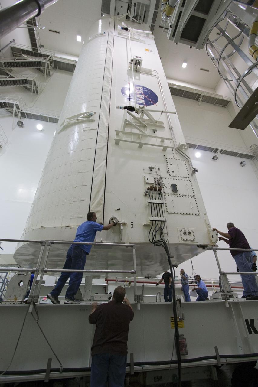 CAPE CANAVERAL, Fla. -- After being rotated from a horizontal to vertical position, the canister that contains the Raffaello multi-purpose logistics module, or MPLM, for the STS-135 mission, is lowered onto a transportation vehicle in the Canister Rotation Facility at NASA's Kennedy Space Center in Florida.     Commander Chris Ferguson, Pilot Doug Hurley and Mission Specialists Sandra Magnus and Rex Walheim are targeted to lift off on space shuttle Atlantis July 8, taking with them the MPLM packed with supplies, logistics and spare parts to the International Space Station. The STS-135 mission also will fly a system to investigate the potential for robotically refueling existing spacecraft and return a failed ammonia pump module to help NASA better understand the failure mechanism and improve pump designs for future systems. STS-135 will be the 33rd flight of Atlantis, the 37th shuttle mission to the space station, and the 135th and final mission of NASA's Space Shuttle Program. For more information, visit www.nasa.gov/mission_pages/shuttle/shuttlemissions/sts135/index.html. Photo credit: NASA/Jack Pfaller