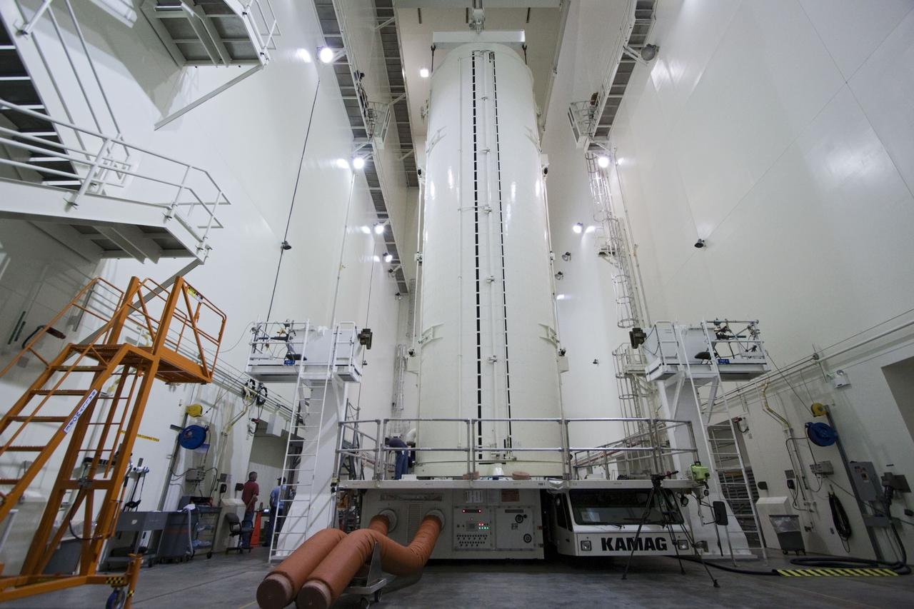 CAPE CANAVERAL, Fla. -- After being rotated from a horizontal to vertical position, the canister that contains the Raffaello multi-purpose logistics module, or MPLM, for the STS-135 mission, has been lowered onto a transportation vehicle in the Canister Rotation Facility at NASA's Kennedy Space Center in Florida.     Commander Chris Ferguson, Pilot Doug Hurley and Mission Specialists Sandra Magnus and Rex Walheim are targeted to lift off on space shuttle Atlantis July 8, taking with them the MPLM packed with supplies, logistics and spare parts to the International Space Station. The STS-135 mission also will fly a system to investigate the potential for robotically refueling existing spacecraft and return a failed ammonia pump module to help NASA better understand the failure mechanism and improve pump designs for future systems. STS-135 will be the 33rd flight of Atlantis, the 37th shuttle mission to the space station, and the 135th and final mission of NASA's Space Shuttle Program. For more information, visit www.nasa.gov/mission_pages/shuttle/shuttlemissions/sts135/index.html. Photo credit: NASA/Jack Pfaller