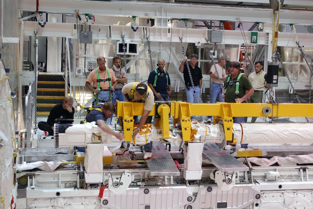 CAPE CANAVERAL, Fla. -- In Orbiter Processing Facility-1 at NASA's Kennedy Space Center in Florida, workers disconnect the remote manipulator system, or RMS, from space shuttle Endeavour's payload bay.     The removal is part of Endeavour's transition and retirement processing. Endeavour is being prepared for public display at the California Science Center in Los Angeles. Endeavour flew 25 missions, spent 299 days in space, orbited Earth 4,671 times and traveled 122,883,151 miles over the course of its 19-year career.  Photo credit: NASA/Tim Jacobs