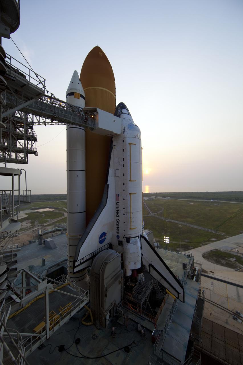CAPE CANAVERAL, Fla. -- The sun rises above the horizon casting a shimmering glow on space shuttle Atlantis standing majestically on its seaside launch pad at NASA's Kennedy Space Center in Florida. Atlantis' payload, the Raffaello multi-purpose logistics module (MPLM) has been delivered to the pad and one more milestone is met for Atlantis' STS-135 mission to the International Space Station.               Commander Chris Ferguson, Pilot Doug Hurley and Mission Specialists Sandra Magnus and Rex Walheim are targeted to lift off on Atlantis July 8, taking with them the MPLM packed with supplies, logistics and spare parts to the station. The STS-135 mission also will fly a system to investigate the potential for robotically refueling existing satellites and return a failed ammonia pump module to help NASA better understand the failure mechanism and improve pump designs for future systems. STS-135 will be the 33rd flight of Atlantis, the 37th shuttle mission to the space station, and the 135th and final mission of NASA's Space Shuttle Program. For more information visit, www.nasa.gov/mission_pages/shuttle/shuttlemissions/sts135/index.html. Photo credit: NASA/Dimitri Gerondidakis