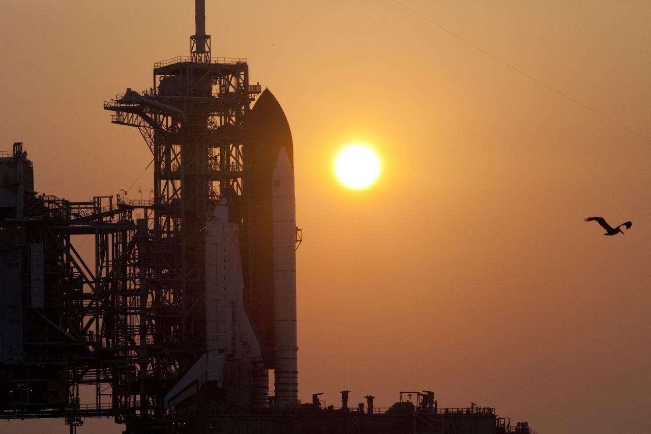CAPE CANAVERAL, Fla. -- A hazy sun sets over Launch Pad 39A at NASA's Kennedy Space Center in Florida as space shuttle Atlantis awaits delivery of the Raffaello multi-purpose logistics module (MPLM) in its transportation canister. Once delivered, the canister will be lifted to the payload changeout room. The payload ground-handling mechanism then will be used to transfer Raffaello out of the canister into Atlantis' payload bay. Next, the rotating service structure that protects the shuttle from the elements and provides access will be rotated back into place.            Commander Chris Ferguson, Pilot Doug Hurley and Mission Specialists Sandra Magnus and Rex Walheim are targeted to lift off on Atlantis July 8, taking with them the MPLM packed with supplies, logistics and spare parts to the station. The STS-135 mission also will fly a system to investigate the potential for robotically refueling existing satellites and return a failed ammonia pump module to help NASA better understand the failure mechanism and improve pump designs for future systems. STS-135 will be the 33rd flight of Atlantis, the 37th shuttle mission to the space station, and the 135th and final mission of NASA's Space Shuttle Program. For more information visit, www.nasa.gov/mission_pages/shuttle/shuttlemissions/sts135/index.html. Photo credit: NASA/Frank Michaux