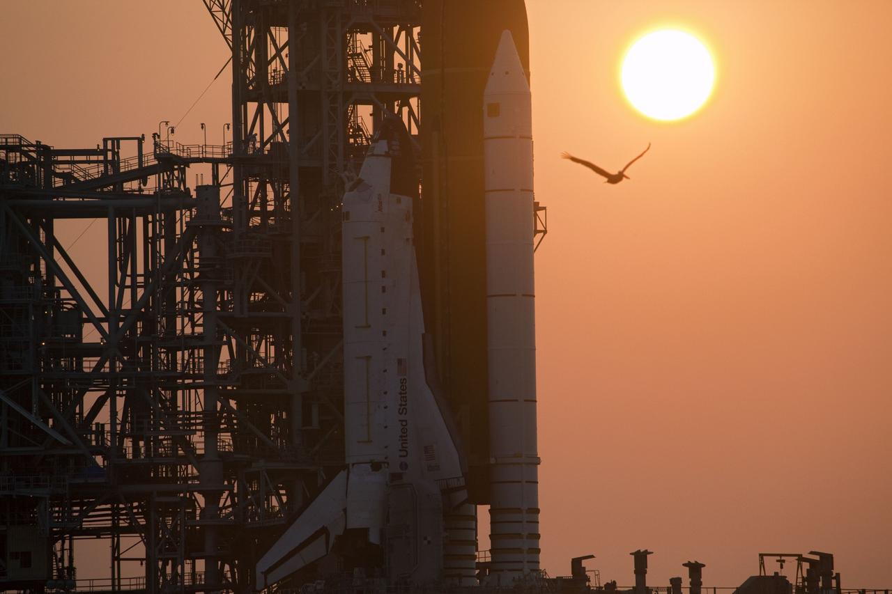 CAPE CANAVERAL, Fla. -- A hazy sun sets over Launch Pad 39A at NASA's Kennedy Space Center in Florida as space shuttle Atlantis awaits delivery of the Raffaello multi-purpose logistics module (MPLM) in its transportation canister. Once delivered, the canister will be lifted to the payload changeout room. The payload ground-handling mechanism then will be used to transfer Raffaello out of the canister into Atlantis' payload bay. Next, the rotating service structure that protects the shuttle from the elements and provides access will be rotated back into place.            Commander Chris Ferguson, Pilot Doug Hurley and Mission Specialists Sandra Magnus and Rex Walheim are targeted to lift off on Atlantis July 8, taking with them the MPLM packed with supplies, logistics and spare parts to the station. The STS-135 mission also will fly a system to investigate the potential for robotically refueling existing satellites and return a failed ammonia pump module to help NASA better understand the failure mechanism and improve pump designs for future systems. STS-135 will be the 33rd flight of Atlantis, the 37th shuttle mission to the space station, and the 135th and final mission of NASA's Space Shuttle Program. For more information visit, www.nasa.gov/mission_pages/shuttle/shuttlemissions/sts135/index.html. Photo credit: NASA/Frank Michaux