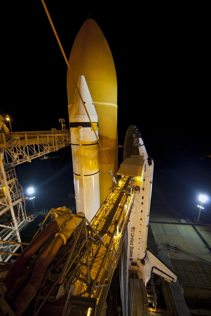 CAPE CANAVERAL, Fla. -- On Launch Pad 39A at NASA's Kennedy Space Center in Florida, the access arm supporting the pad's White Room is in place against space shuttle Atlantis. The room provides workers and astronauts an entry point to the shuttle's crew compartment. The Raffaello multi-purpose logistics module (MPLM) payload for space shuttle Atlantis' STS-135 mission to the International Space Station has arrived at the pad. The payload canister will be lifted to the payload changeout room and the payload ground-handling mechanism then will be used to transfer Raffaello out of the canister into Atlantis' payload bay. Next, the rotating service structure that protects the shuttle from the elements and provides access will be rotated back into place.            Commander Chris Ferguson, Pilot Doug Hurley and Mission Specialists Sandra Magnus and Rex Walheim are targeted to lift off on Atlantis July 8, taking with them the MPLM packed with supplies, logistics and spare parts to the station. The STS-135 mission also will fly a system to investigate the potential for robotically refueling existing satellites and return a failed ammonia pump module to help NASA better understand the failure mechanism and improve pump designs for future systems. STS-135 will be the 33rd flight of Atlantis, the 37th shuttle mission to the space station, and the 135th and final mission of NASA's Space Shuttle Program. For more information visit, www.nasa.gov/mission_pages/shuttle/shuttlemissions/sts135/index.html. Photo credit: NASA/Frank Michaux