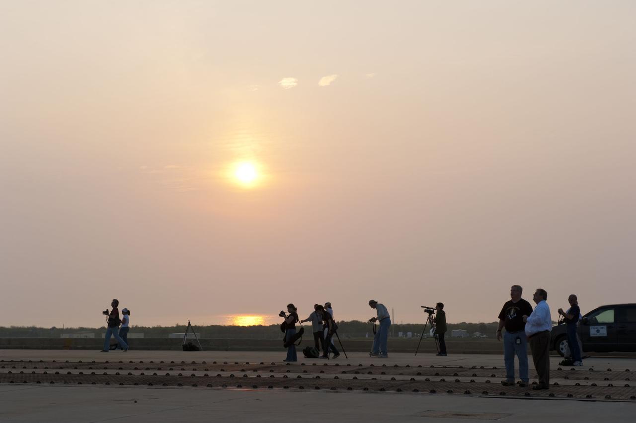 CAPE CANAVERAL, Fla. -- At NASA's Kennedy Space Center in Florida media take advantage of the beautiful sunrise to snap photos of space shuttle Atlantis on Launch Pad 39A after the payload canister carrying the Raffaello multi-purpose logistics module (MPLM) was lifted into the payload changeout room on the rotating service structure.          Commander Chris Ferguson, Pilot Doug Hurley and Mission Specialists Sandra Magnus and Rex Walheim are targeted to lift off on space shuttle Atlantis July 8, taking with them the MPLM packed with supplies, logistics and spare parts to the International Space Station. The STS-135 mission also will fly a system to investigate the potential for robotically refueling existing satellites and return a failed ammonia pump module to help NASA better understand the failure mechanism and improve pump designs for future systems. STS-135 will be the 33rd flight of Atlantis, the 37th shuttle mission to the space station, and the 135th and final mission of NASA's Space Shuttle Program. For more information visit, www.nasa.gov/mission_pages/shuttle/shuttlemissions/sts135/index.html. Photo credit: NASA/Kim Shiflett