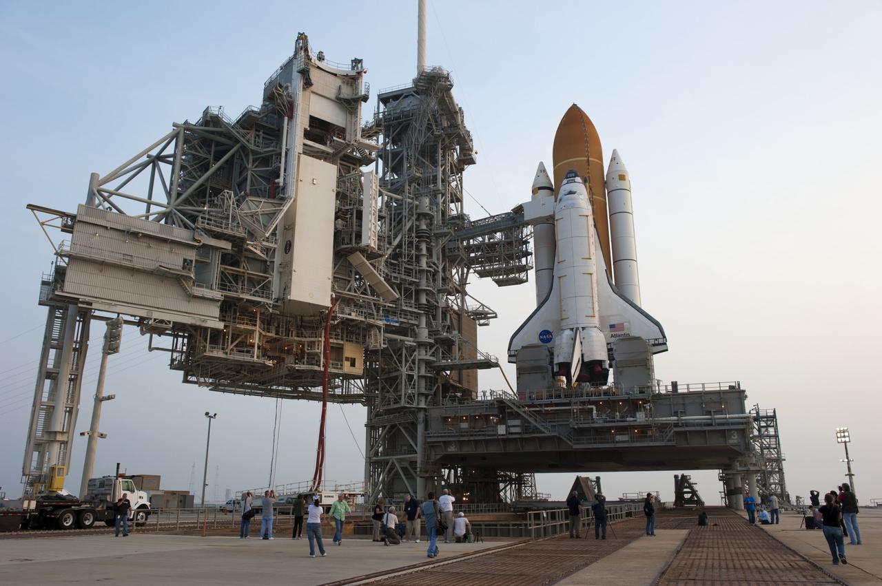 CAPE CANAVERAL, Fla. -- At NASA's Kennedy Space Center in Florida media snap photos of space shuttle Atlantis on Launch Pad 39A after the payload canister carrying the Raffaello multi-purpose logistics module (MPLM) was lifted into the payload changeout room on the rotating service structure.      Commander Chris Ferguson, Pilot Doug Hurley and Mission Specialists Sandra Magnus and Rex Walheim are targeted to lift off on space shuttle Atlantis July 8, taking with them the MPLM packed with supplies, logistics and spare parts to the International Space Station. The STS-135 mission also will fly a system to investigate the potential for robotically refueling existing satellites and return a failed ammonia pump module to help NASA better understand the failure mechanism and improve pump designs for future systems. STS-135 will be the 33rd flight of Atlantis, the 37th shuttle mission to the space station, and the 135th and final mission of NASA's Space Shuttle Program. For more information visit, www.nasa.gov/mission_pages/shuttle/shuttlemissions/sts135/index.html. Photo credit: NASA/Kim Shiflett