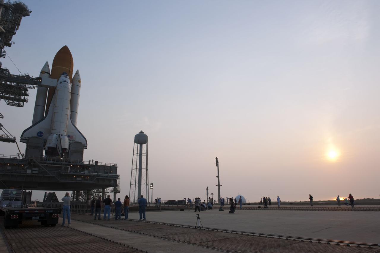 CAPE CANAVERAL, Fla. -- At NASA's Kennedy Space Center in Florida media take advantage of the beautiful sunrise to snap photos of space shuttle Atlantis on Launch Pad 39A after the payload canister carrying the Raffaello multi-purpose logistics module (MPLM) was lifted into the payload changeout room on the rotating service structure.    Commander Chris Ferguson, Pilot Doug Hurley and Mission Specialists Sandra Magnus and Rex Walheim are targeted to lift off on space shuttle Atlantis July 8, taking with them the MPLM packed with supplies, logistics and spare parts to the International Space Station. The STS-135 mission also will fly a system to investigate the potential for robotically refueling existing satellites and return a failed ammonia pump module to help NASA better understand the failure mechanism and improve pump designs for future systems. STS-135 will be the 33rd flight of Atlantis, the 37th shuttle mission to the space station, and the 135th and final mission of NASA's Space Shuttle Program. For more information visit, www.nasa.gov/mission_pages/shuttle/shuttlemissions/sts135/index.html. Photo credit: NASA/Kim Shiflett