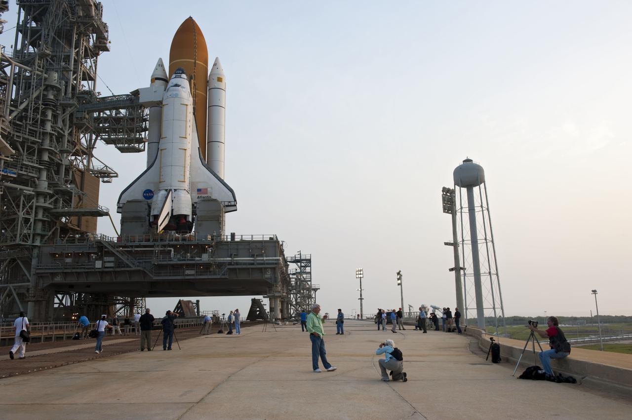 CAPE CANAVERAL, Fla. -- At NASA's Kennedy Space Center in Florida media snap photos of space shuttle Atlantis on Launch Pad 39A after the payload canister carrying the Raffaello multi-purpose logistics module (MPLM) was lifted into the payload changeout room on the rotating service structure.        Commander Chris Ferguson, Pilot Doug Hurley and Mission Specialists Sandra Magnus and Rex Walheim are targeted to lift off on space shuttle Atlantis July 8, taking with them the MPLM packed with supplies, logistics and spare parts to the International Space Station. The STS-135 mission also will fly a system to investigate the potential for robotically refueling existing satellites and return a failed ammonia pump module to help NASA better understand the failure mechanism and improve pump designs for future systems. STS-135 will be the 33rd flight of Atlantis, the 37th shuttle mission to the space station, and the 135th and final mission of NASA's Space Shuttle Program. For more information visit, www.nasa.gov/mission_pages/shuttle/shuttlemissions/sts135/index.html. Photo credit: NASA/Kim Shiflett