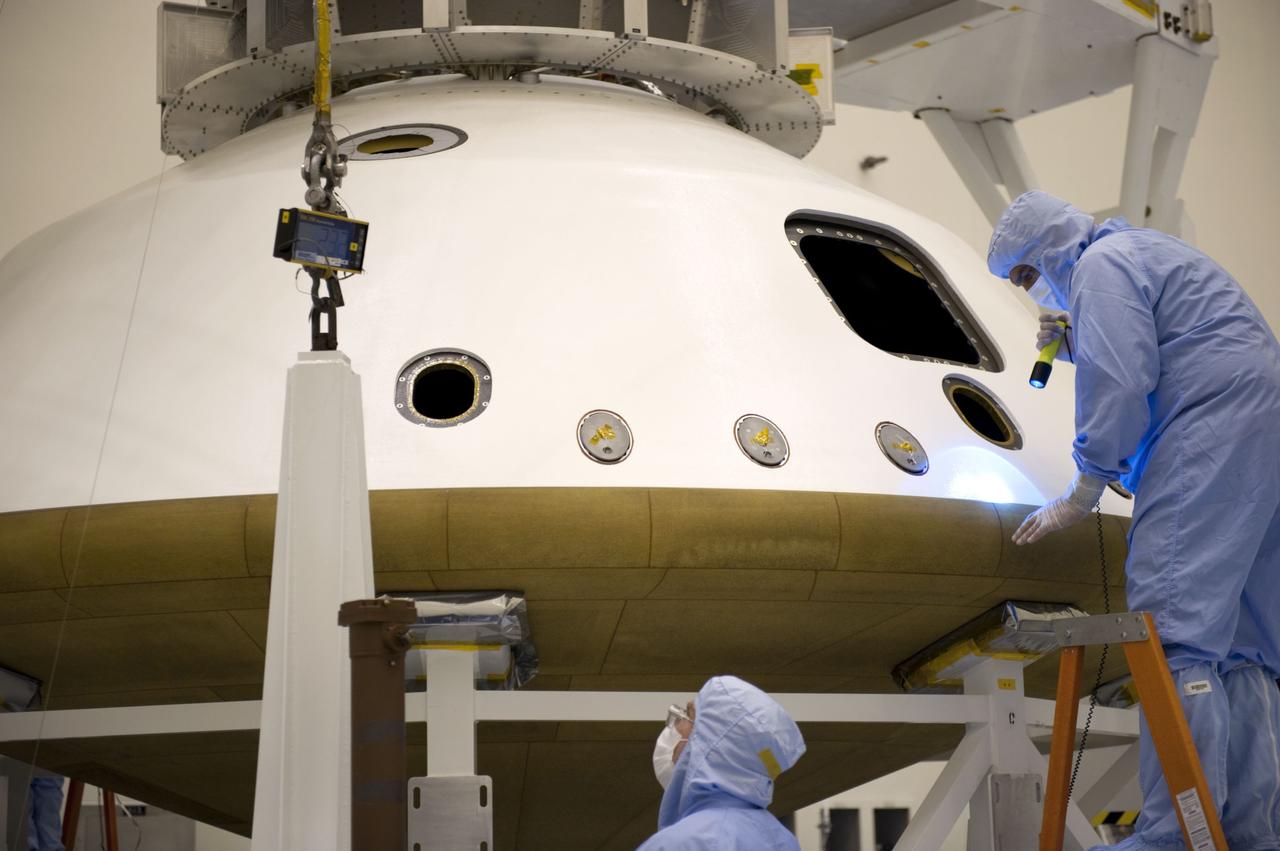 Cape Canaveral, Fla. -- At the Payload Hazardous Servicing Facility at NASA's Kennedy Space Center in Florida, technicians inspect the joint where two components of the aeroshell meet. The aeroshell is an element of NASA's Mars Science Laboratory (MSL) and consists of the spacecraft's heat shield and the backshell which carries the parachute and several components used during later stages of entry, descent and landing. MSL's components include a compact car-sized rover, Curiosity, which has 10 science instruments designed to search for evidence on whether Mars has had environments favorable to microbial life, including chemical ingredients for life. The unique rover will use a laser to look inside rocks and release its gasses so that the rover’s spectrometer can analyze and send the data back to Earth. Launch of MSL aboard a United Launch Alliance Atlas V rocket is scheduled for Nov. 25 from Space Launch Complex 41 on Cape Canaveral Air Force Station in Florida. For more information, visit http://www.nasa.gov/msl. Photo credit: NASA/Kim Shiflett