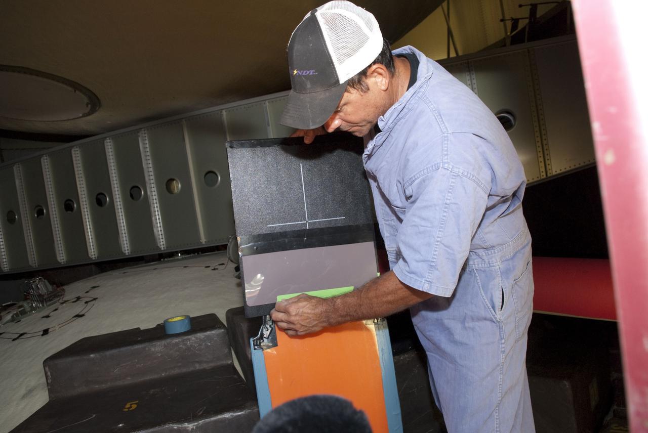CAPE CANAVERAL, Fla. -- At NASA's Kennedy Space Center in Florida, technicians prepare to conduct Computed Radiography (CR) X-ray scans of 50 support beams, called stringers, on the shuttle-facing side of Atlantis' external tank at Launch Pad 39A. The hi-tech images will be taken of the tops and bottoms of the 21-foot long beams, which are located on the tank's intertank section. Here, a technician prepares an image plate inside the outertank. The scans follow a June 15th tanking test when the launch team filled then drained the tank of about 535,000 gallons of liquid hydrogen and liquid oxygen, just like for a launch. Earlier this year, managers directed teams to make the same stringer modifications to Atlantis' tank, ET-138, as they had after small cracks in the support beams of shuttle Discovery's STS-133 mission external tank were discovered. The scans will confirm there are no issues with Atlantis' tank.                STS-135 Commander Chris Ferguson, Pilot Doug Hurley and Mission Specialists Sandy Magnus and Rex Walheim are targeted to lift off on space shuttle Atlantis July 8, taking with them the MPLM packed with supplies, logistics and spare parts to the International Space Station. The STS-135 mission also will fly a system to investigate the potential for robotically refueling existing satellites and return a failed ammonia pump module to help NASA better understand the failure mechanism and improve pump designs for future systems. STS-135 will be the 33rd flight of Atlantis, the 37th shuttle mission to the space station, and the 135th and final mission of NASA's Space Shuttle Program. For more information visit, www.nasa.gov/mission_pages/shuttle/shuttlemissions/sts135/index.html. Photo credit: NASA/Jim Grossmann