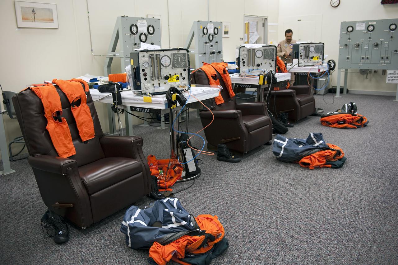 CAPE CANAVERAL, Fla. -- In the Operations and Checkout Building at NASA's Kennedy Space Center in Florida, suit technician Ray Cuevas prepares the orange launch and landing suits for the STS-135 crew members. The crew is at Kennedy to participate in a launch countdown dress rehearsal called the Terminal Countdown Demonstration Test (TCDT) and related training in preparation for the upcoming STS-135 mission.                 Atlantis and its crew are targeted to lift off July 8, taking with them the Raffaello multi-purpose logistics module packed with supplies and spare parts to the International Space Station. The STS-135 mission also will fly a system to investigate the potential for robotically refueling existing satellites and return a failed ammonia pump module to help NASA better understand the failure mechanism and improve pump designs for future systems. STS-135 will be the 33rd flight of Atlantis, the 37th shuttle mission to the space station, and the 135th and final mission of NASA's Space Shuttle Program. For more information visit, www.nasa.gov/mission_pages/shuttle/shuttlemissions/sts135/index.html.  Photo credit: NASA/Kim Shiflett