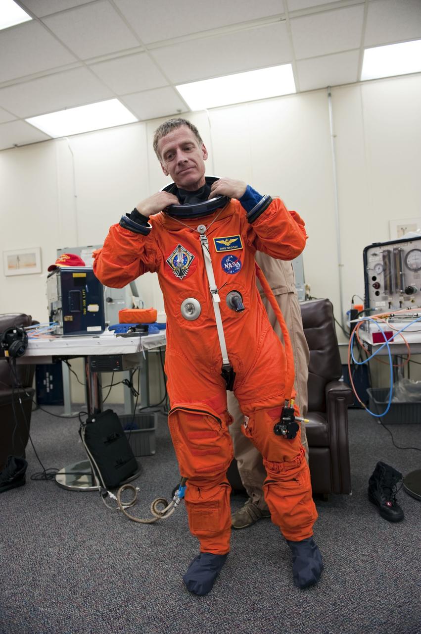 CAPE CANAVERAL, Fla. -- In the Operations and Checkout Building at NASA's Kennedy Space Center in Florida, Commander Chris Ferguson checks the fit of his launch and landing suit. The STS-135 crew is at Kennedy to participate in a launch countdown dress rehearsal called the Terminal Countdown Demonstration Test (TCDT) and related training in preparation for the upcoming STS-135 mission.                Atlantis and its crew are targeted to lift off July 8, taking with them the Raffaello multi-purpose logistics module packed with supplies and spare parts to the International Space Station. The STS-135 mission also will fly a system to investigate the potential for robotically refueling existing satellites and return a failed ammonia pump module to help NASA better understand the failure mechanism and improve pump designs for future systems. STS-135 will be the 33rd flight of Atlantis, the 37th shuttle mission to the space station, and the 135th and final mission of NASA's Space Shuttle Program. For more information visit, www.nasa.gov/mission_pages/shuttle/shuttlemissions/sts135/index.html.  Photo credit: NASA/Kim Shiflett