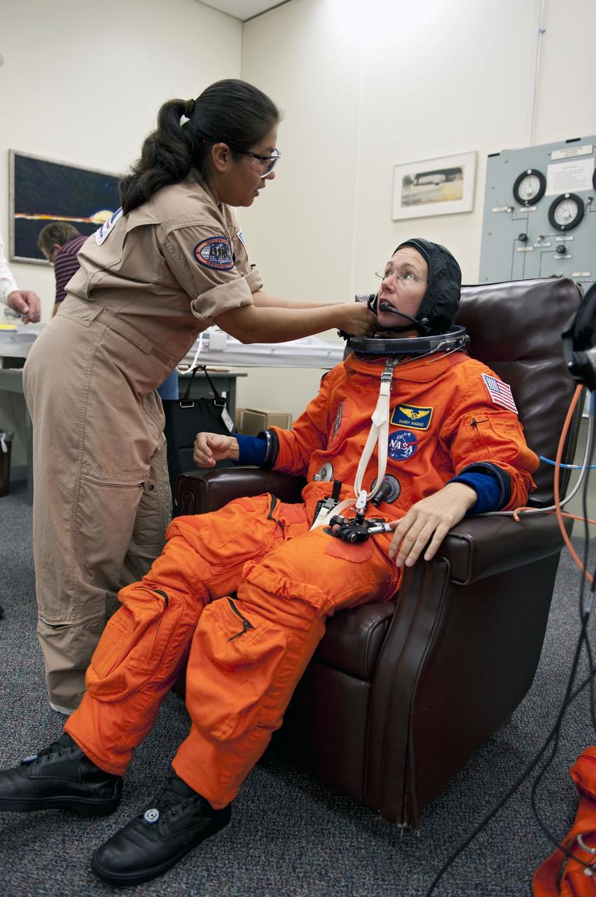 CAPE CANAVERAL, Fla. -- In the Operations and Checkout Building at NASA's Kennedy Space Center in Florida, Mission Specialist Sandy Magnus has her launch and landing suit checked by suit technician Cathy Cruz. The STS-135 crew is at Kennedy to participate in a launch countdown dress rehearsal called the Terminal Countdown Demonstration Test (TCDT) and related training in preparation for the upcoming STS-135 mission.      Atlantis and its crew are targeted to lift off July 8, taking with them the Raffaello multi-purpose logistics module packed with supplies and spare parts to the International Space Station. The STS-135 mission also will fly a system to investigate the potential for robotically refueling existing satellites and return a failed ammonia pump module to help NASA better understand the failure mechanism and improve pump designs for future systems. STS-135 will be the 33rd flight of Atlantis, the 37th shuttle mission to the space station, and the 135th and final mission of NASA's Space Shuttle Program. For more information visit, www.nasa.gov/mission_pages/shuttle/shuttlemissions/sts135/index.html.  Photo credit: NASA/Kim Shiflett