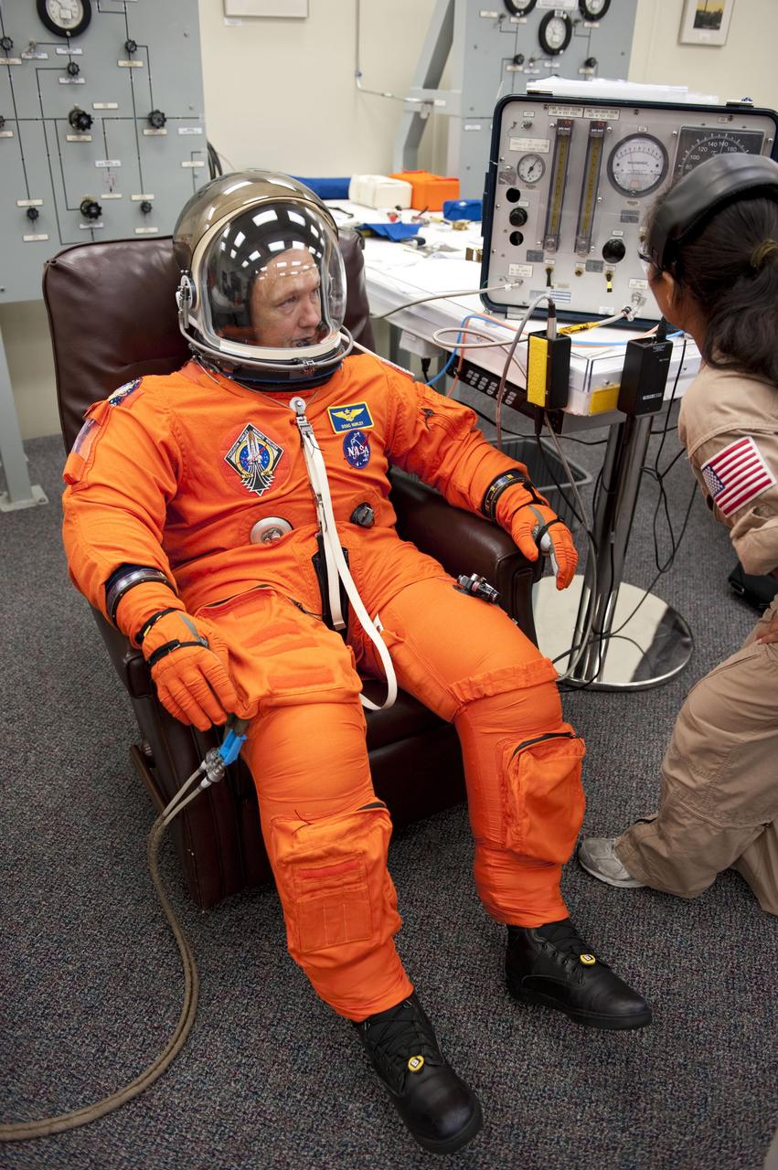 CAPE CANAVERAL, Fla. -- In the Operations and Checkout Building at NASA's Kennedy Space Center in Florida, Pilot Doug Hurley has his launch and landing suit checked by suit technician Cathy Cruz. The STS-135 crew is at Kennedy to participate in a launch countdown dress rehearsal called the Terminal Countdown Demonstration Test (TCDT) and related training in preparation for the upcoming STS-135 mission.    Atlantis and its crew are targeted to lift off July 8, taking with them the Raffaello multi-purpose logistics module packed with supplies and spare parts to the International Space Station. The STS-135 mission also will fly a system to investigate the potential for robotically refueling existing satellites and return a failed ammonia pump module to help NASA better understand the failure mechanism and improve pump designs for future systems. STS-135 will be the 33rd flight of Atlantis, the 37th shuttle mission to the space station, and the 135th and final mission of NASA's Space Shuttle Program. For more information visit, www.nasa.gov/mission_pages/shuttle/shuttlemissions/sts135/index.html.  Photo credit: NASA/Kim Shiflett