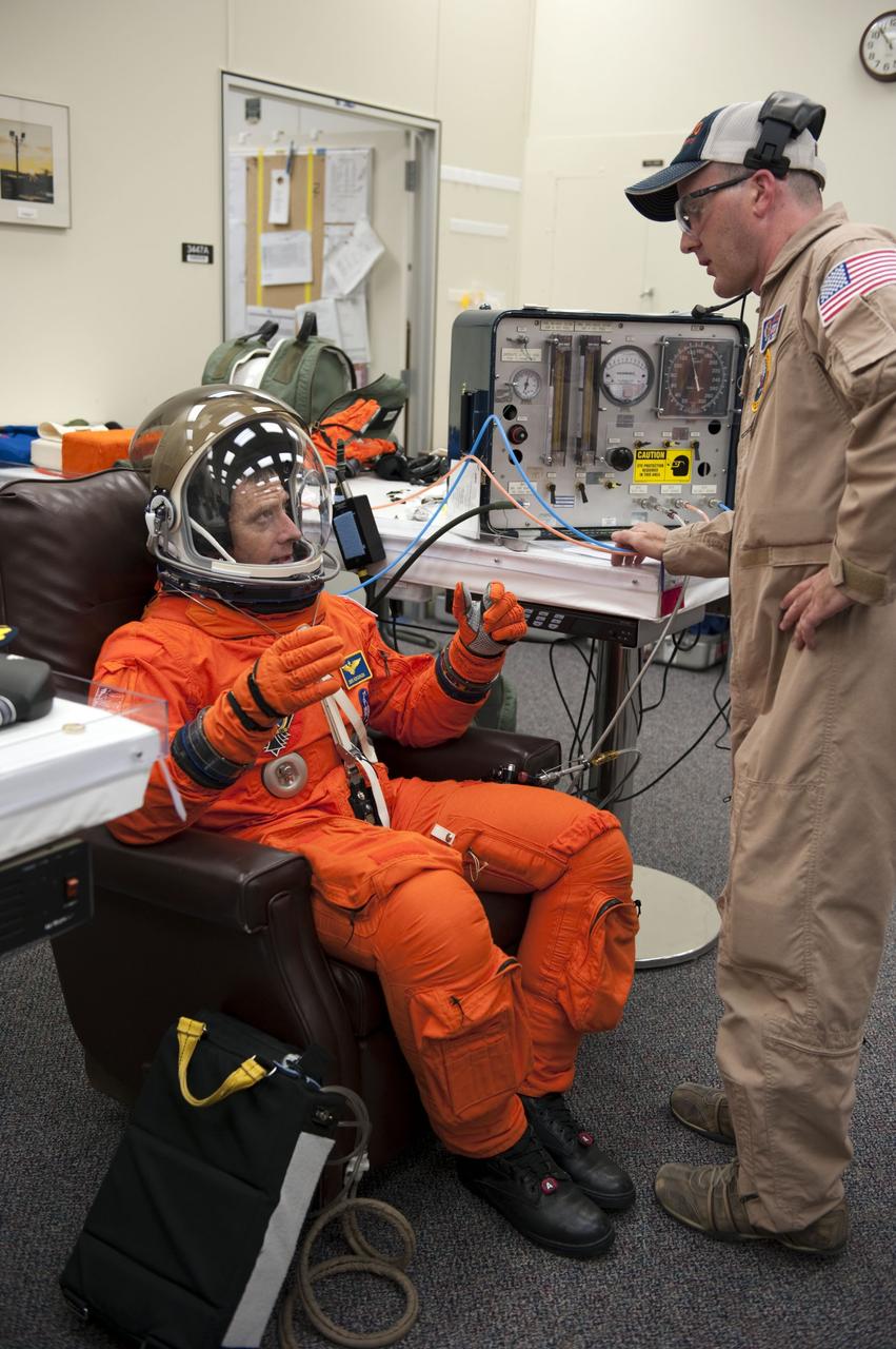 CAPE CANAVERAL, Fla. -- In the Operations and Checkout Building at NASA's Kennedy Space Center in Florida, Commander Chris Ferguson has his launch and landing suit checked by suit technician Jeremy Spruell. The STS-135 crew is at Kennedy to participate in a launch countdown dress rehearsal called the Terminal Countdown Demonstration Test (TCDT) and related training in preparation for the upcoming STS-135 mission.          Atlantis and its crew are targeted to lift off July 8, taking with them the Raffaello multi-purpose logistics module packed with supplies and spare parts to the International Space Station. The STS-135 mission also will fly a system to investigate the potential for robotically refueling existing satellites and return a failed ammonia pump module to help NASA better understand the failure mechanism and improve pump designs for future systems. STS-135 will be the 33rd flight of Atlantis, the 37th shuttle mission to the space station, and the 135th and final mission of NASA's Space Shuttle Program. For more information visit, www.nasa.gov/mission_pages/shuttle/shuttlemissions/sts135/index.html.  Photo credit: NASA/Kim Shiflett