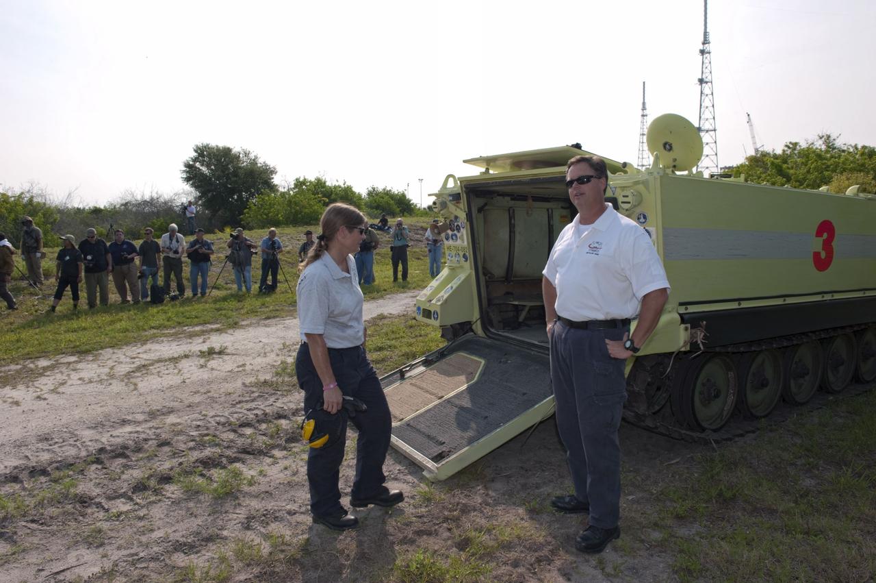 CAPE CANAVERAL, Fla. -- Media snap photos of the STS-135 crew (out of frame) during their M113 armored personnel carrier training at NASA's Kennedy Space Center in Florida. Seen here are Battalion Chief David Seymour (right) and Carmel Shearer, pad rescue team driver. An M113 is kept at the foot of the launch pad in case an emergency exit from the launch pad is needed and every shuttle crew is trained on driving the vehicle before launch. The crew is at Kennedy to participate in a launch countdown dress rehearsal called the Terminal Countdown Demonstration Test (TCDT) and related training. Atlantis and its crew are targeted to lift off July 8, taking with them the Raffaello multi-purpose logistics module packed with supplies and spare parts to the International Space Station. The STS-135 mission also will fly a system to investigate the potential for robotically refueling existing satellites and return a failed ammonia pump module to help NASA better understand the failure mechanism and improve pump designs for future systems. STS-135 will be the 33rd flight of Atlantis, the 37th shuttle mission to the space station, and the 135th and final mission of NASA's Space Shuttle Program. For more information visit, www.nasa.gov/mission_pages/shuttle/shuttlemissions/sts135/index.html. Photo credit: NASA/Kim Shiflett