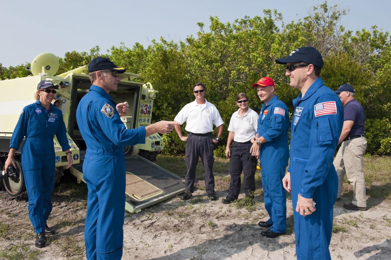 CAPE CANAVERAL, Fla. -- Battalion Chief David Seymour (center) and Carmel Shearer, pad rescue team driver, join in as space shuttle Atlantis' STS-135 crew members share a light moment during M113 armored personnel carrier training at NASA's Kennedy Space Center in Florida. From left are Mission Specialist Sandy Magnus, Commander Chris Ferguson, Pilot Doug Hurley and Mission Specialist Rex Walheim. An M113 is kept at the foot of the launch pad in case an emergency exit from the launch pad is needed and every shuttle crew is trained on driving the vehicle before launch. The STS-135 crew is at Kennedy to participate in a launch countdown dress rehearsal called the Terminal Countdown Demonstration Test (TCDT) and related training. Atlantis and its crew are targeted to lift off July 8, taking with them the Raffaello multi-purpose logistics module packed with supplies and spare parts to the International Space Station. The STS-135 mission also will fly a system to investigate the potential for robotically refueling existing satellites and return a failed ammonia pump module to help NASA better understand the failure mechanism and improve pump designs for future systems. STS-135 will be the 33rd flight of Atlantis, the 37th shuttle mission to the space station, and the 135th and final mission of NASA's Space Shuttle Program. For more information visit, www.nasa.gov/mission_pages/shuttle/shuttlemissions/sts135/index.html. Photo credit: NASA/Kim Shiflett