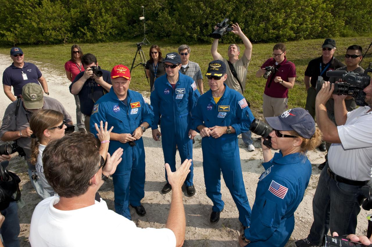 CAPE CANAVERAL, Fla. -- Media snap photos while Battalion Chief David Seymour (left) and Carmel Shearer, pad rescue team driver, instruct shuttle Atlantis' STS-135 crew members during M113 armored personnel carrier training at NASA's Kennedy Space Center in Florida. From left are Pilot Doug Hurley (red cap), Mission Specialist Rex Walheim, Commander Chris Ferguson, Mission Specialist Sandy Magnus (blue cap). An M113 is kept at the foot of the launch pad in case an emergency exit from the launch pad is needed and every shuttle crew is trained on driving the vehicle before launch. The STS-135 crew is at Kennedy to participate in a launch countdown dress rehearsal called the Terminal Countdown Demonstration Test (TCDT) and related training. Atlantis and its crew are targeted to lift off July 8, taking with them the Raffaello multi-purpose logistics module packed with supplies and spare parts to the International Space Station. The STS-135 mission also will fly a system to investigate the potential for robotically refueling existing satellites and return a failed ammonia pump module to help NASA better understand the failure mechanism and improve pump designs for future systems. STS-135 will be the 33rd flight of Atlantis, the 37th shuttle mission to the space station, and the 135th and final mission of NASA's Space Shuttle Program. For more information visit, www.nasa.gov/mission_pages/shuttle/shuttlemissions/sts135/index.html. Photo credit: NASA/Kim Shiflett