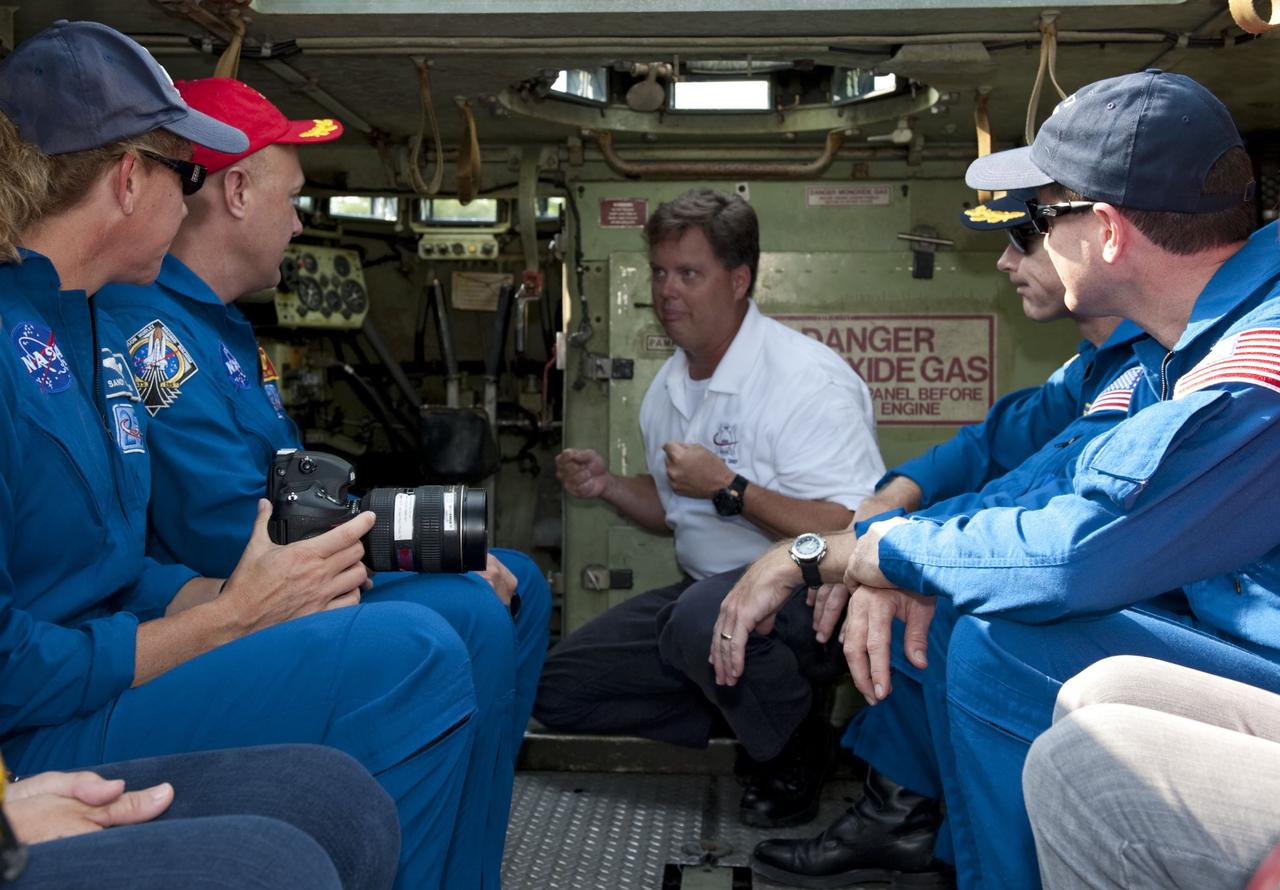 CAPE CANAVERAL, Fla. -- Battalion Chief David Seymour instructs space shuttle Atlantis' STS-135 crew members as they participate in M113 armored personnel carrier training at NASA's Kennedy Space Center in Florida. From left are Mission Specialist Sandy Magnus, Pilot Doug Hurley, Commander Chris Ferguson (partially obscured) and Mission Specialist Rex Walheim. An M113 is kept at the foot of the launch pad in case an emergency exit from the launch pad is needed and every shuttle crew is trained on driving the vehicle before launch. The STS-135 crew is at Kennedy to participate in a launch countdown dress rehearsal called the Terminal Countdown Demonstration Test (TCDT) and related training.        Atlantis and its crew are targeted to lift off July 8, taking with them the Raffaello multi-purpose logistics module packed with supplies and spare parts to the International Space Station. The STS-135 mission also will fly a system to investigate the potential for robotically refueling existing satellites and return a failed ammonia pump module to help NASA better understand the failure mechanism and improve pump designs for future systems. STS-135 will be the 33rd flight of Atlantis, the 37th shuttle mission to the space station, and the 135th and final mission of NASA's Space Shuttle Program. For more information visit, www.nasa.gov/mission_pages/shuttle/shuttlemissions/sts135/index.html. Photo credit: NASA/Kim Shiflett