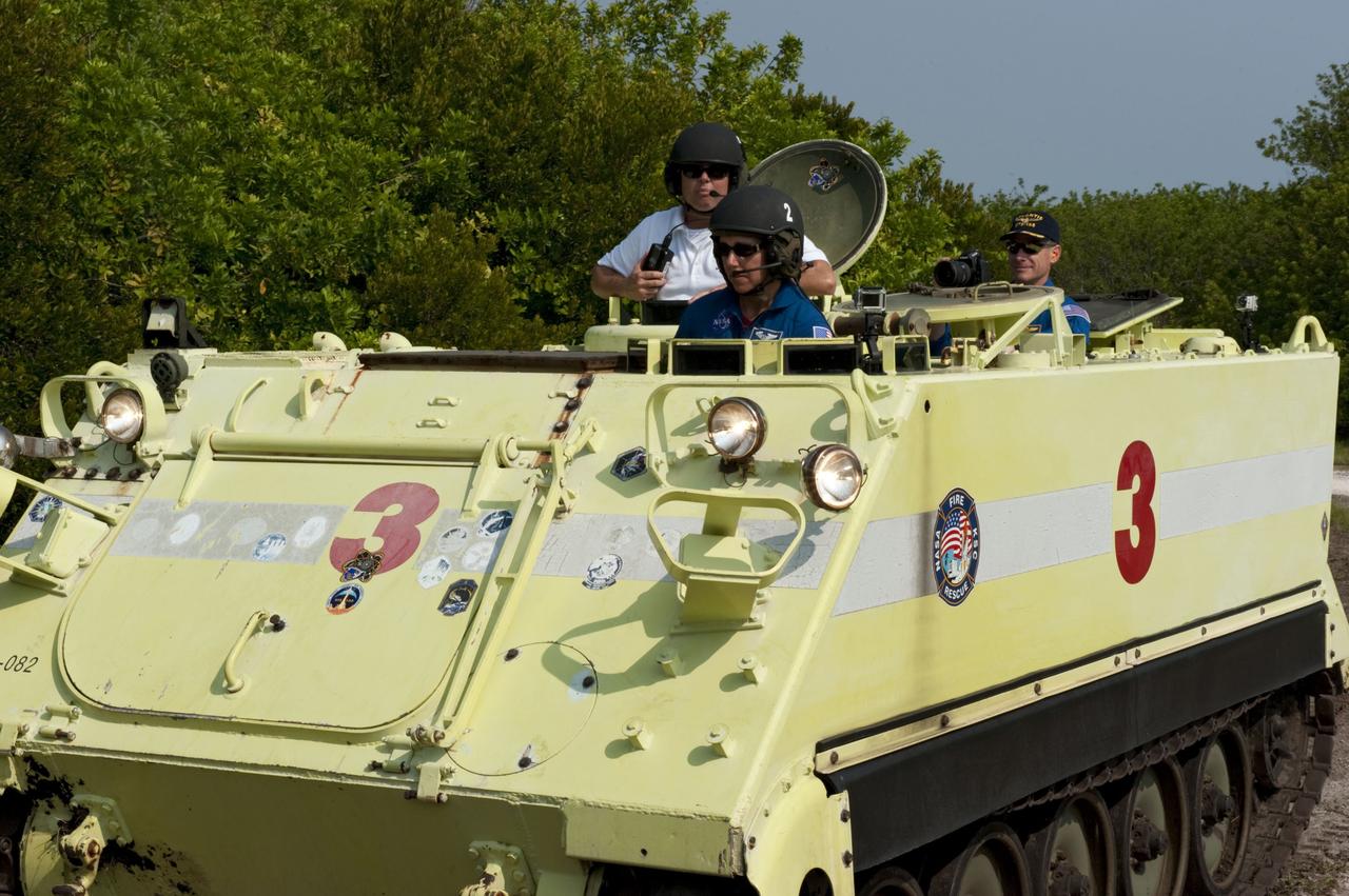 CAPE CANAVERAL, Fla. -- Battalion Chief David Seymour provides supervision while space shuttle Atlantis' STS-135 crew members participate in M113 armored personnel carrier training at NASA's Kennedy Space Center in Florida. Driving the M113 is Mission Specialist Sandy Magnus while Commander Chris Ferguson looks on. An M113 is kept at the foot of the launch pad in case an emergency exit from the launch pad is needed and every shuttle crew is trained on driving the vehicle before launch. The STS-135 crew is at Kennedy to participate in a launch countdown dress rehearsal called the Terminal Countdown Demonstration Test (TCDT) and related training.        Atlantis and its crew are targeted to lift off July 8, taking with them the Raffaello multi-purpose logistics module packed with supplies and spare parts to the International Space Station. The STS-135 mission also will fly a system to investigate the potential for robotically refueling existing satellites and return a failed ammonia pump module to help NASA better understand the failure mechanism and improve pump designs for future systems. STS-135 will be the 33rd flight of Atlantis, the 37th shuttle mission to the space station, and the 135th and final mission of NASA's Space Shuttle Program. For more information visit, www.nasa.gov/mission_pages/shuttle/shuttlemissions/sts135/index.html. Photo credit: NASA/Kim Shiflett